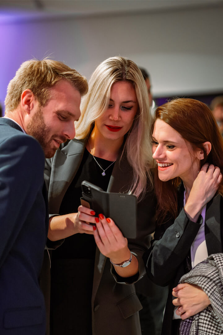 Groupe de participants consultant une tablette lors d’un événement