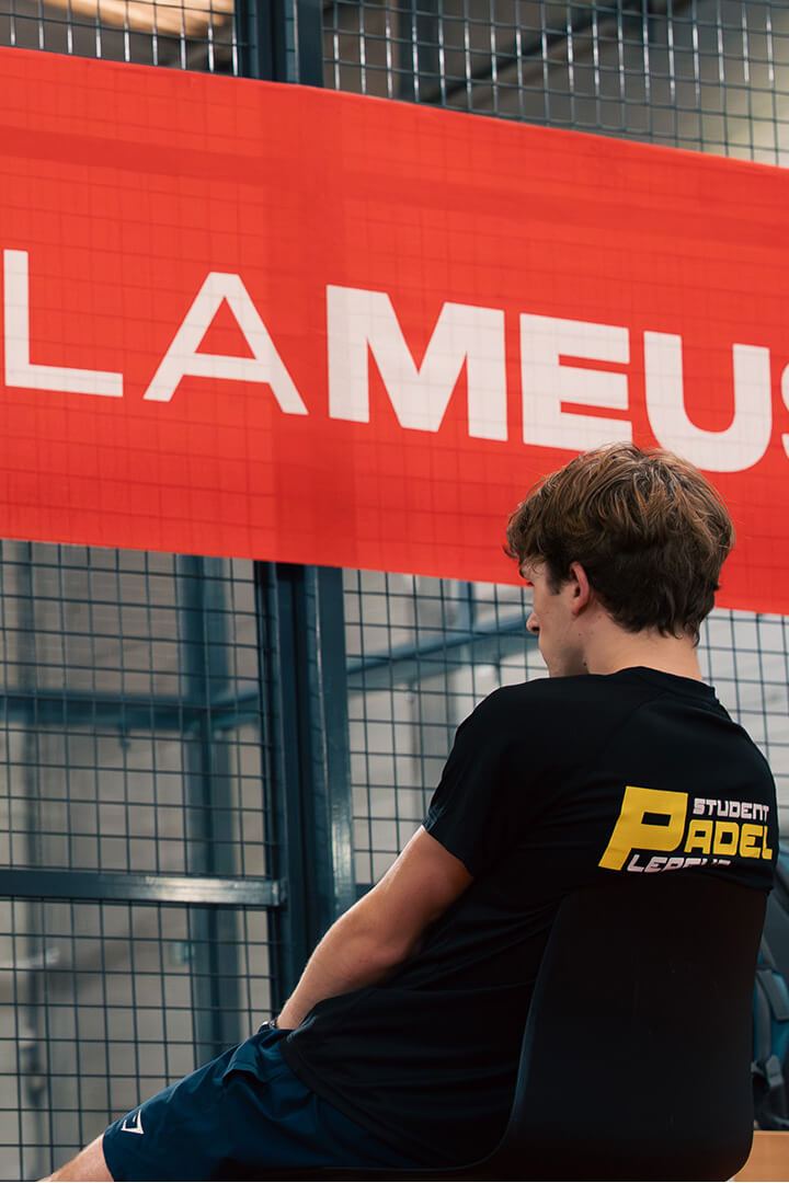 Étudiants observant un match de padel dans un complexe sportif indoor