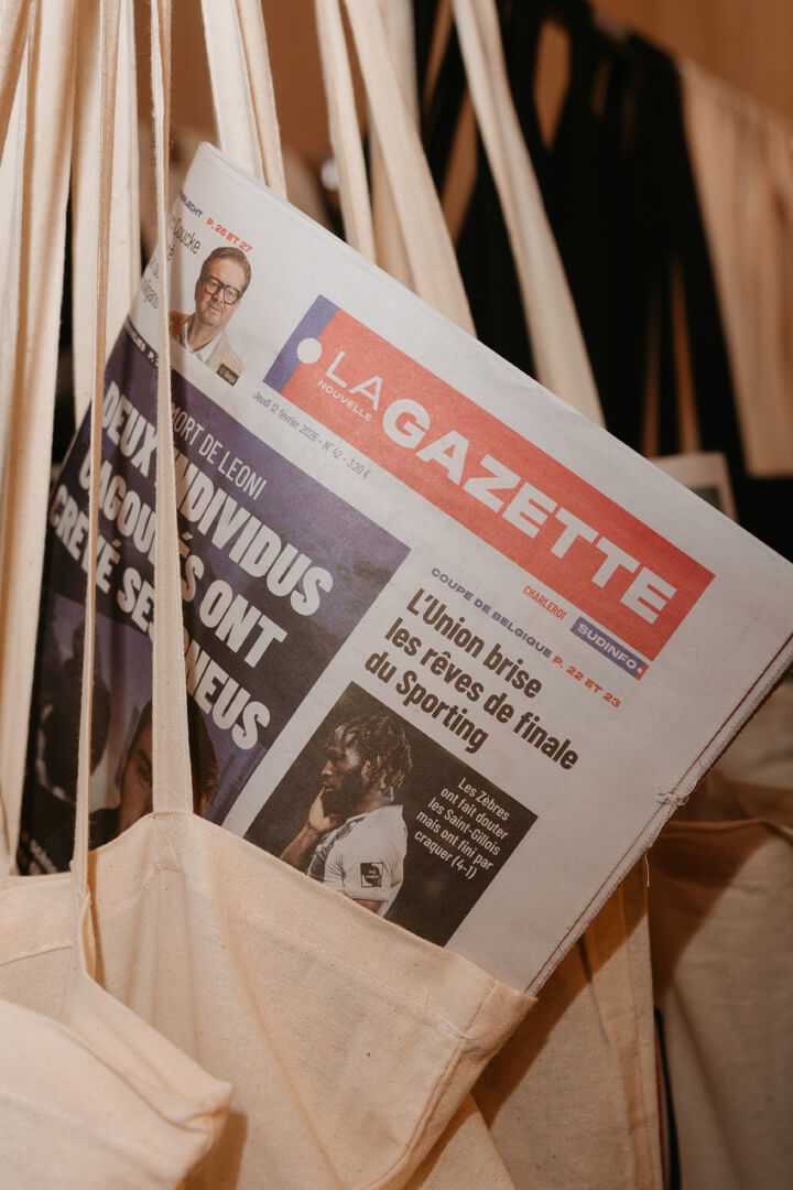 Tote bags contenant des exemplaires du journal La Nouvelle Gazette lors d’un événement