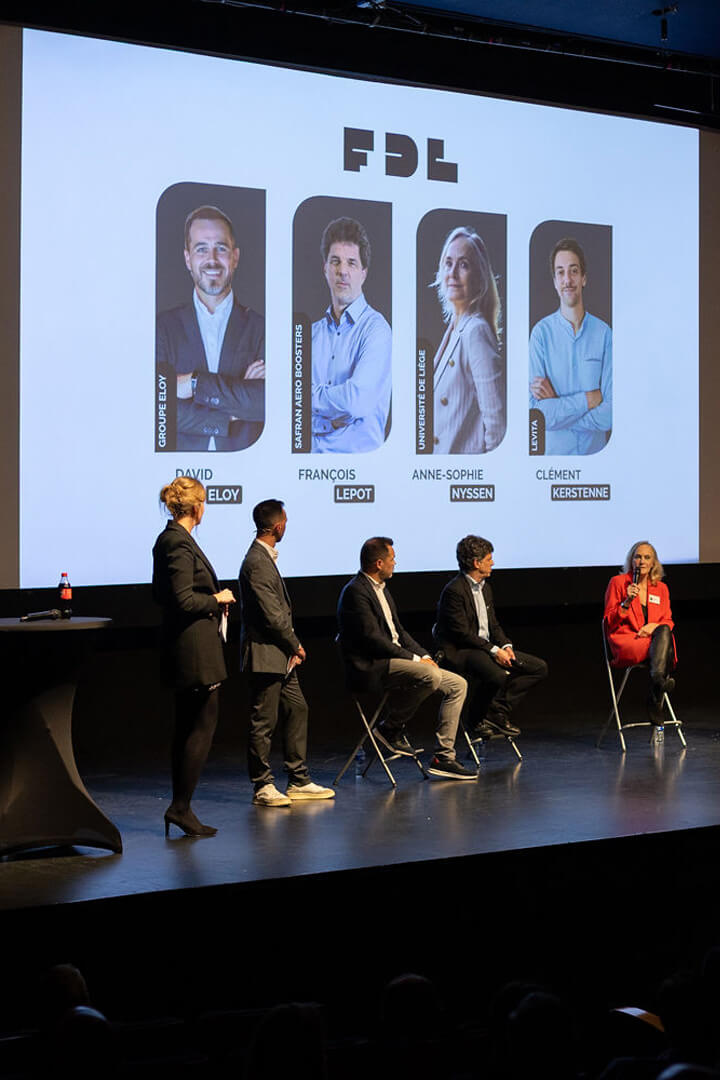 Intervenants assis sur scène lors d’une table ronde avec présentation projetée