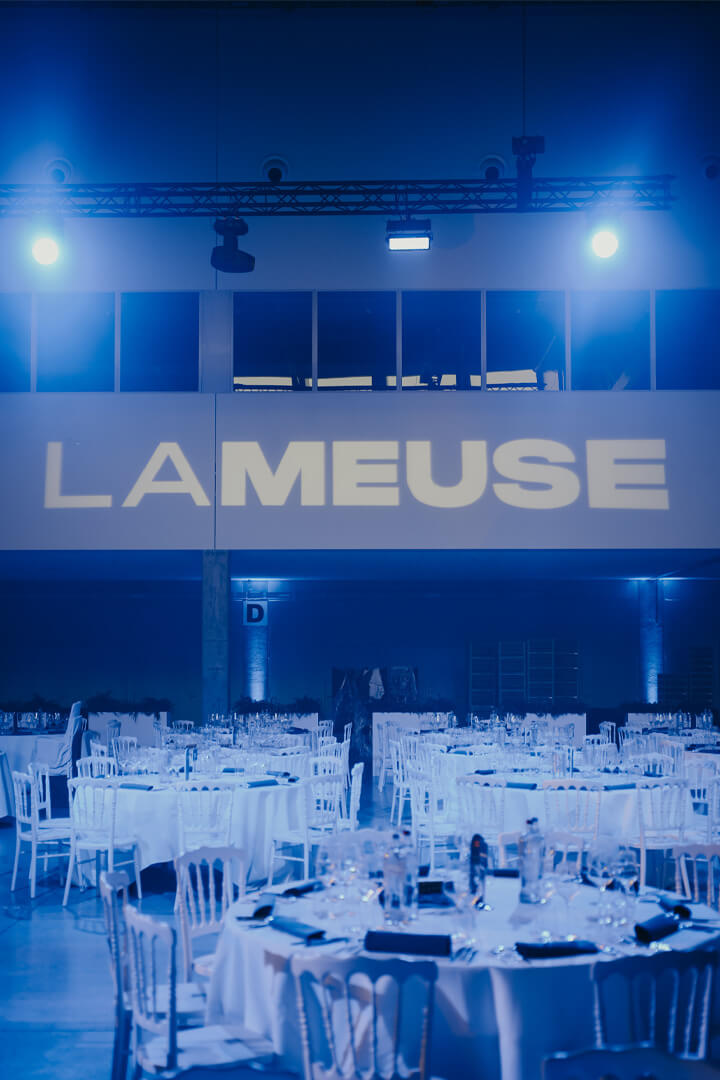 Salle de réception La Meuse avec tables dressées pour un dîner événementiel