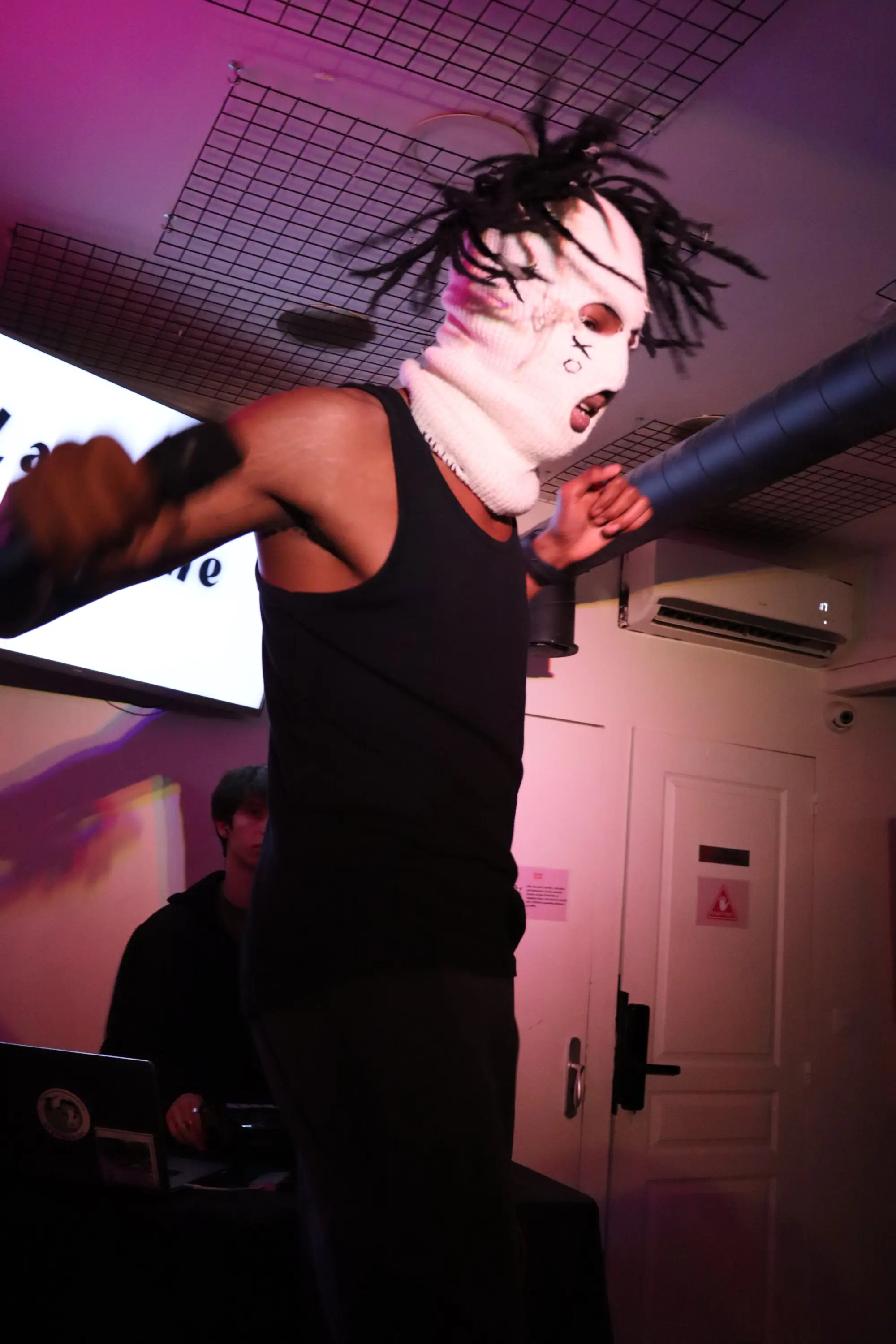 Performance d'un rappeur masqué sur scène, l'énergie de la scène indépendante française.