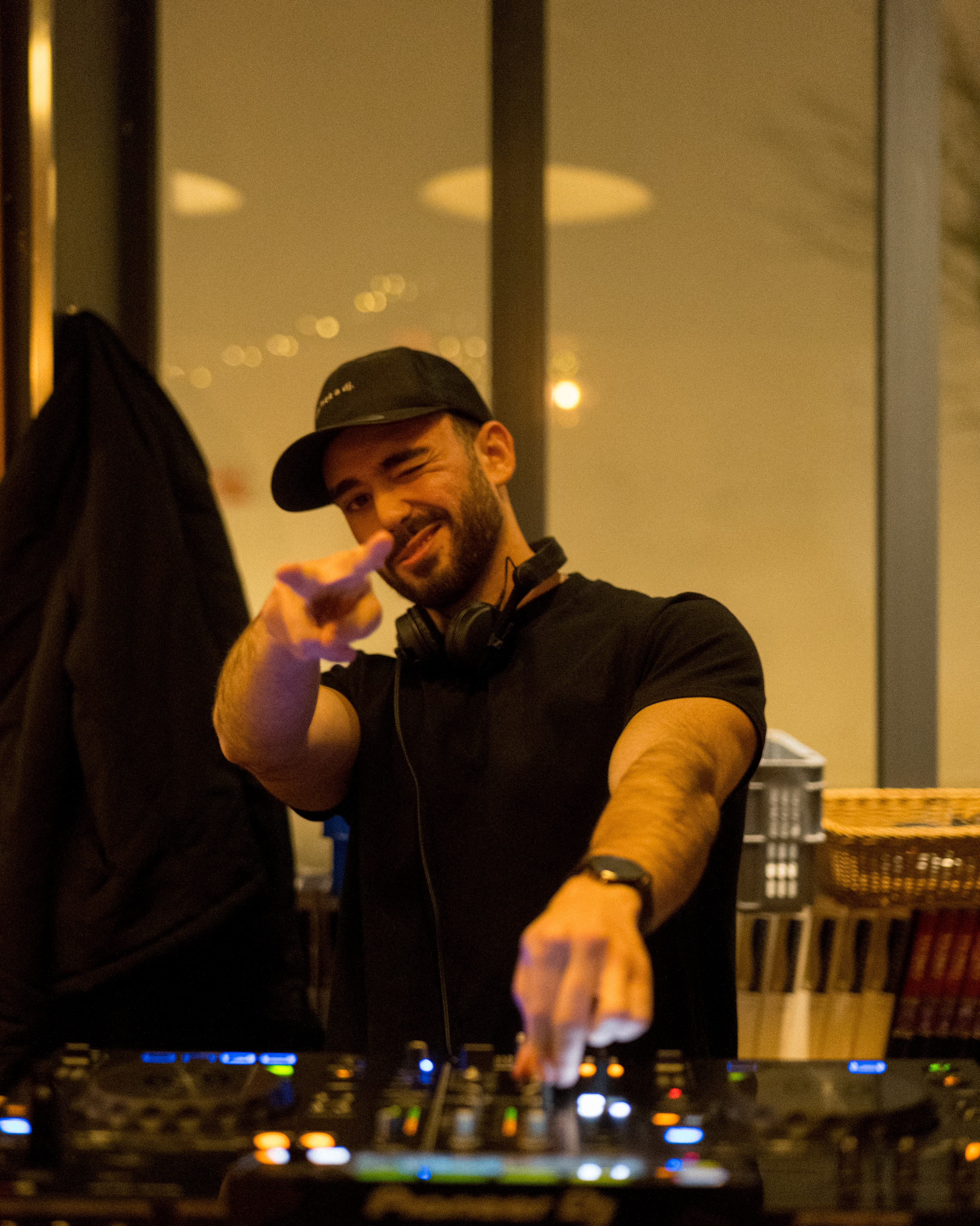 Portrait d'un DJ pointant l'objectif, l'ambiance d'une soirée d'artiste émergent.