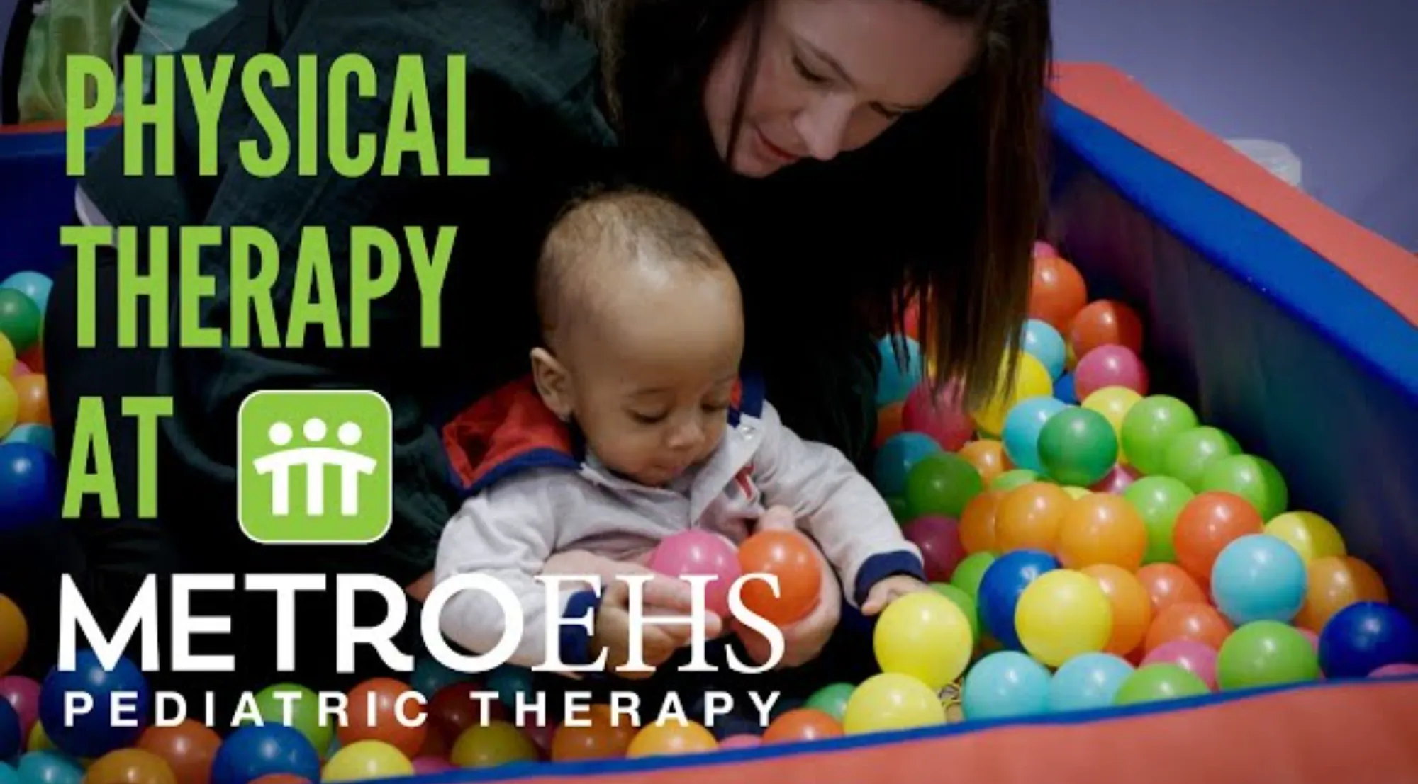 A physical therapist helping a baby play in a ball pit