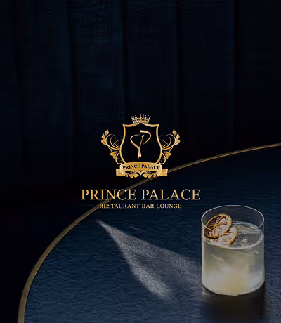 Logo doré de Prince Palace Restaurant Bar Lounge sur fond sombre avec un verre de cocktail glacé.