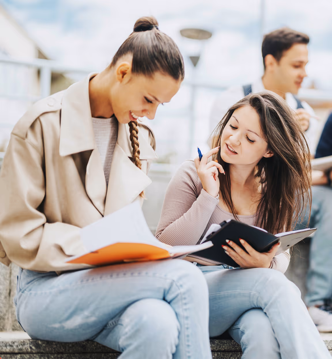 Group of young students writing and studying on campus steps, engaged in leadership development