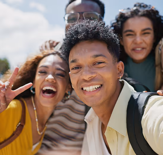 Joyful group of global youth taking a selfie outdoors, celebrating community and mental wellness
