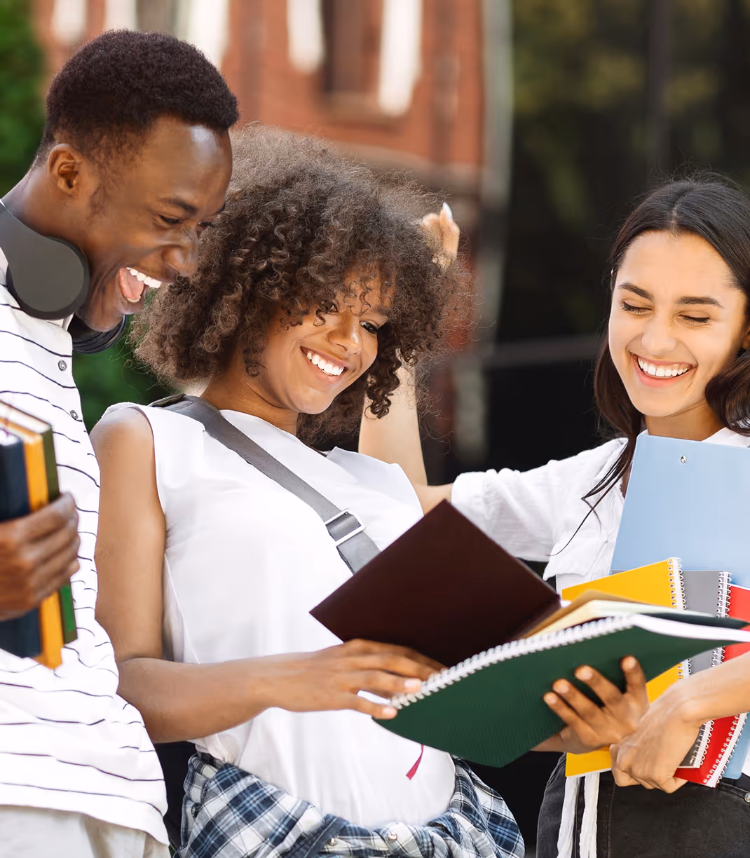 Three joyful students sharing notebooks on campus, reflecting youth mental health and leadership growth