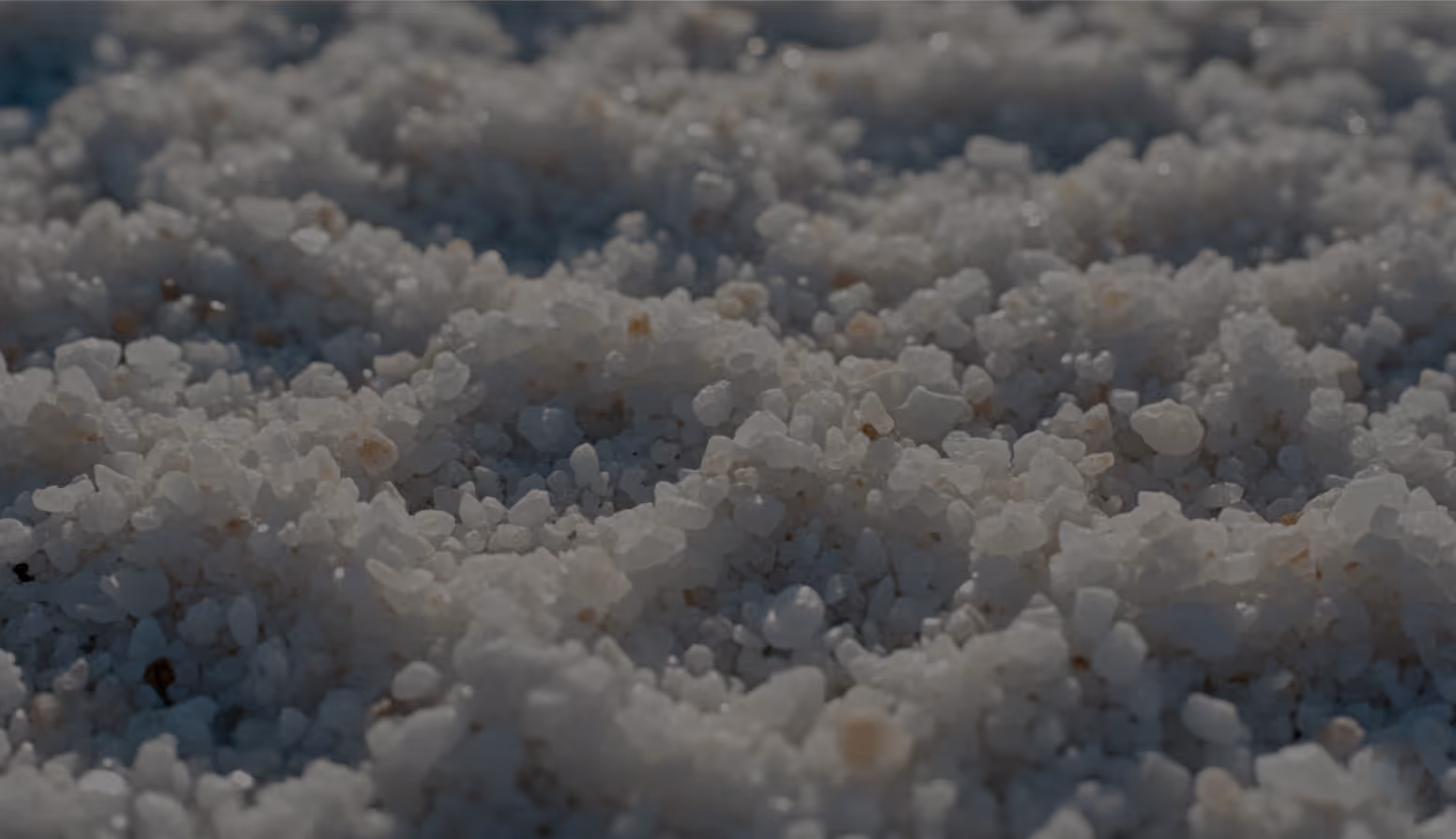Close-up of coarse white salt crystals piled together.