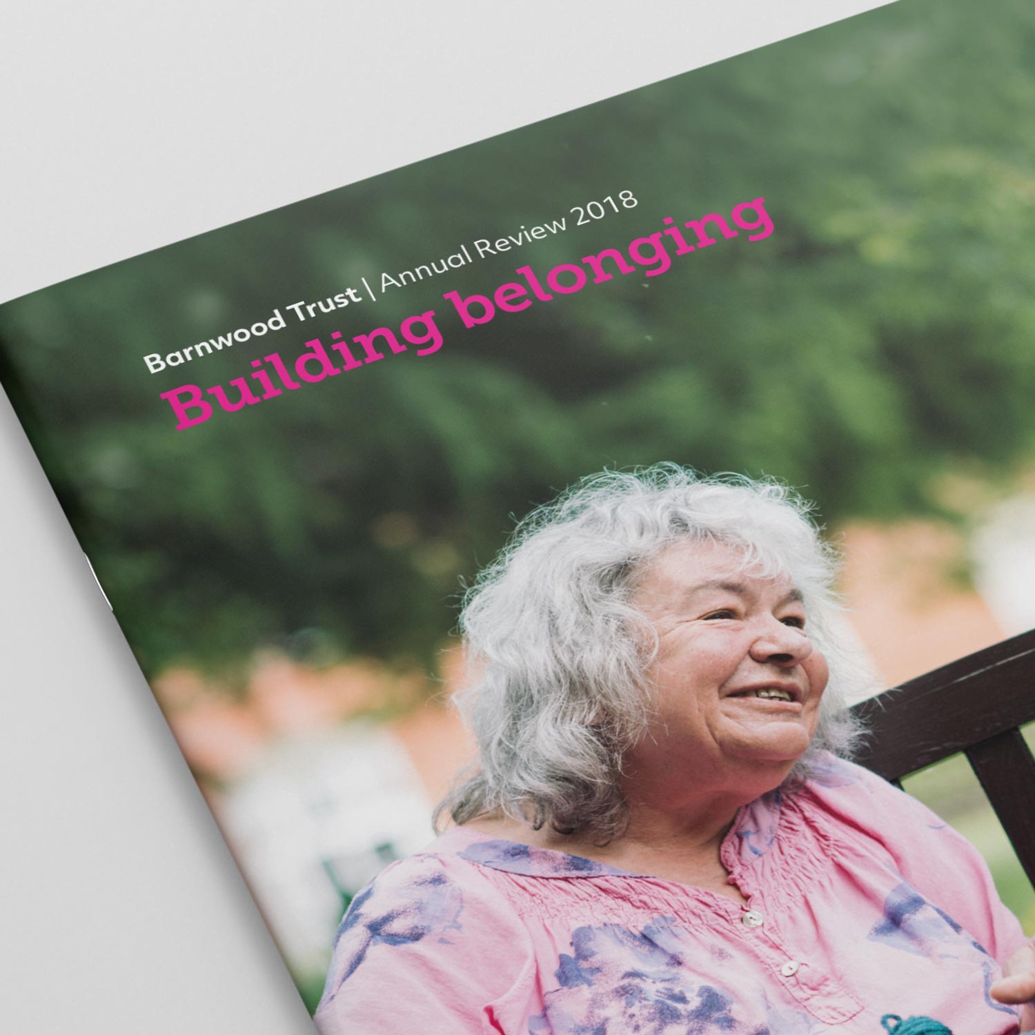 Cover of Barnwood Trust Annual Review 2018 featuring a smiling elderly woman with gray hair wearing a pink floral shirt sitting outdoors.