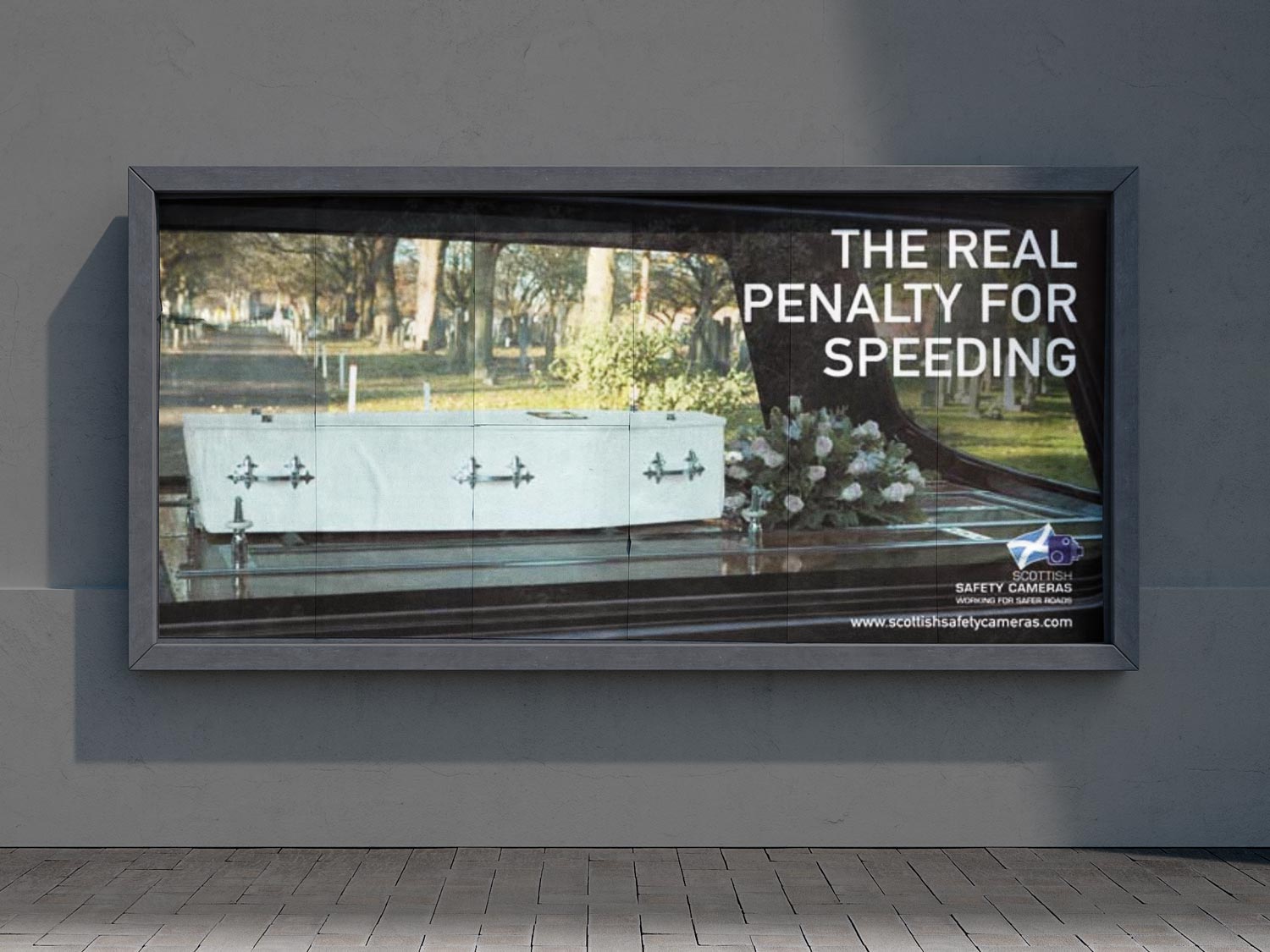 Billboard showing a coffin in a hearse with text 'The real penalty for speeding' promoting Scottish safety cameras.