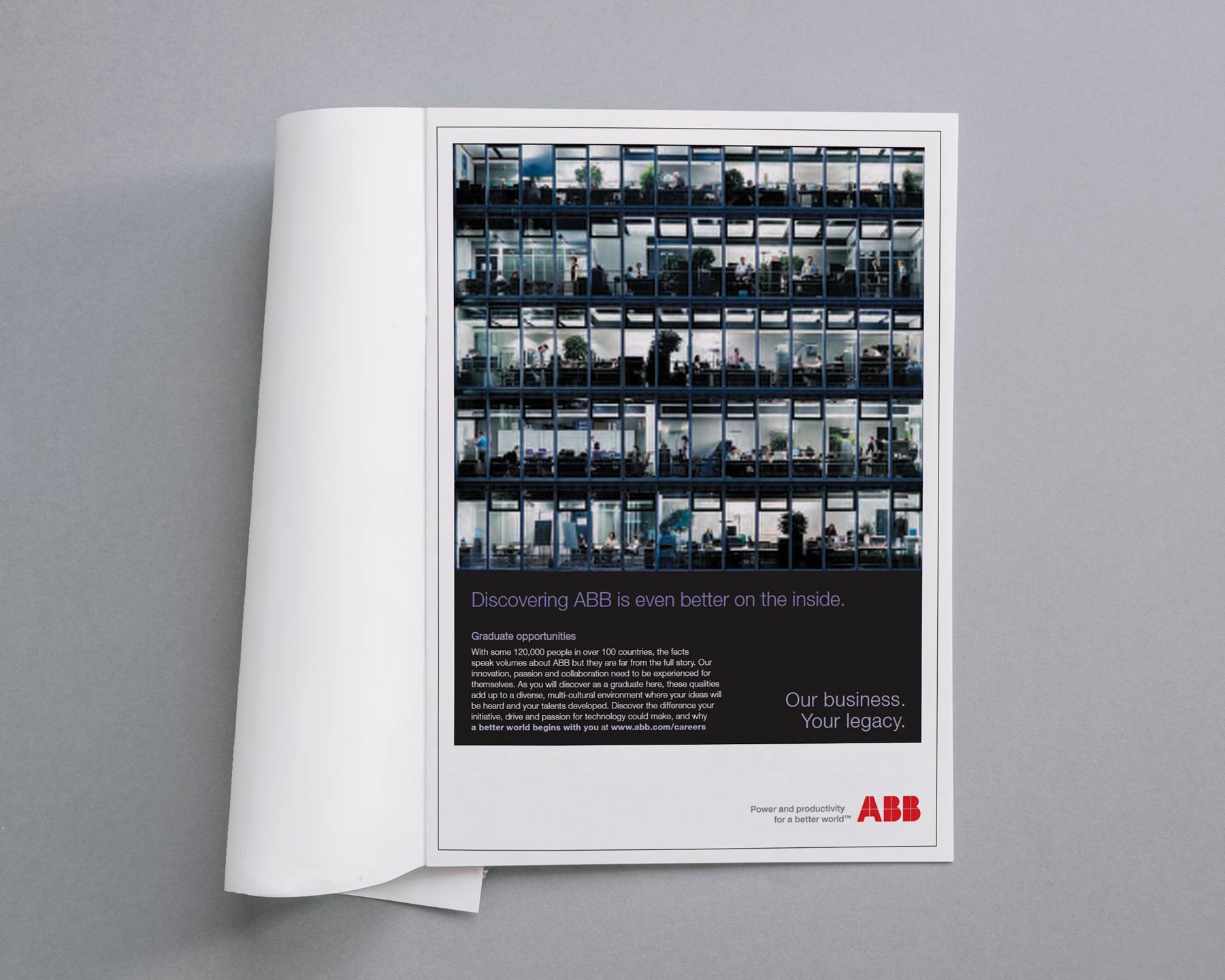 Office building facade showing multiple floors and workers, featuring ABB graduate opportunities and the tagline 'Our business. Your legacy.'