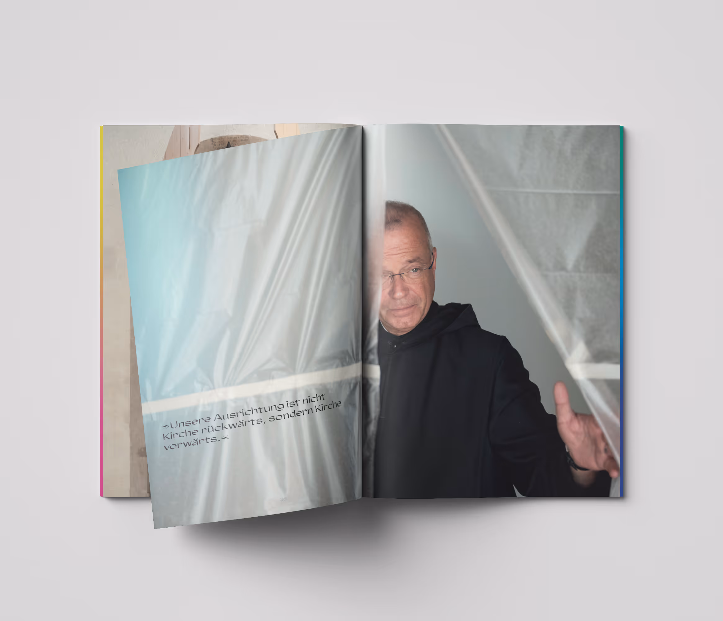 emilo-Magazin Nr. 4 aufgeschlagen:  Frater Emmanuel Rotter schaut durch einen Vorhang aus Baufolie
