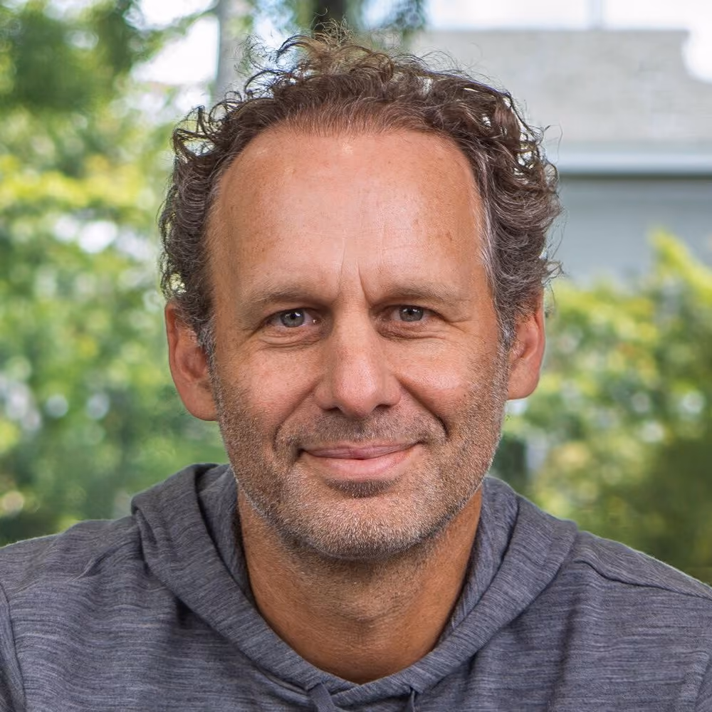 Porträt von Jonathan, lächelnder Mann vor grünem Hintergrund