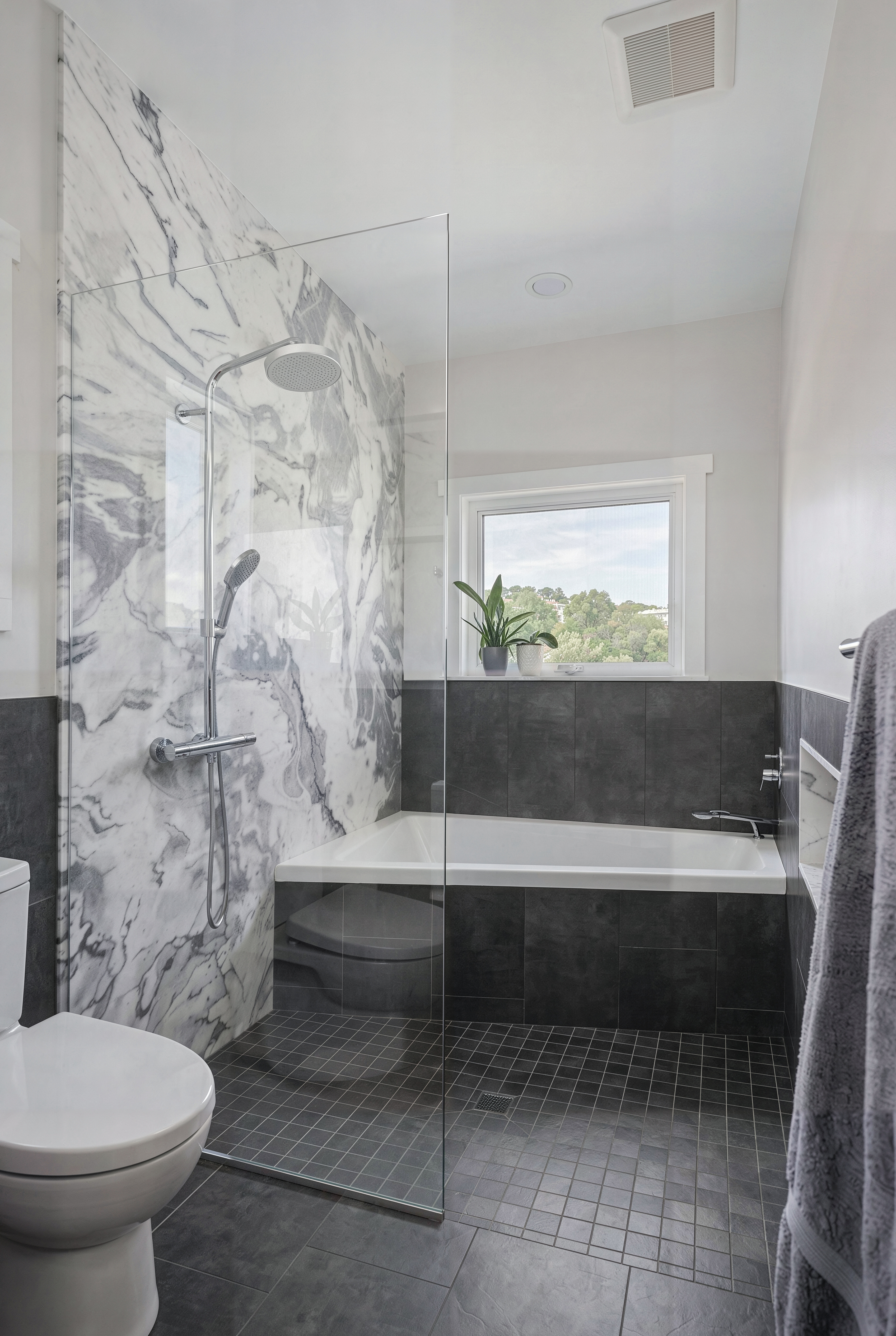 The dramatic shower wall granite and atmospheric black tile in the master bathroom.