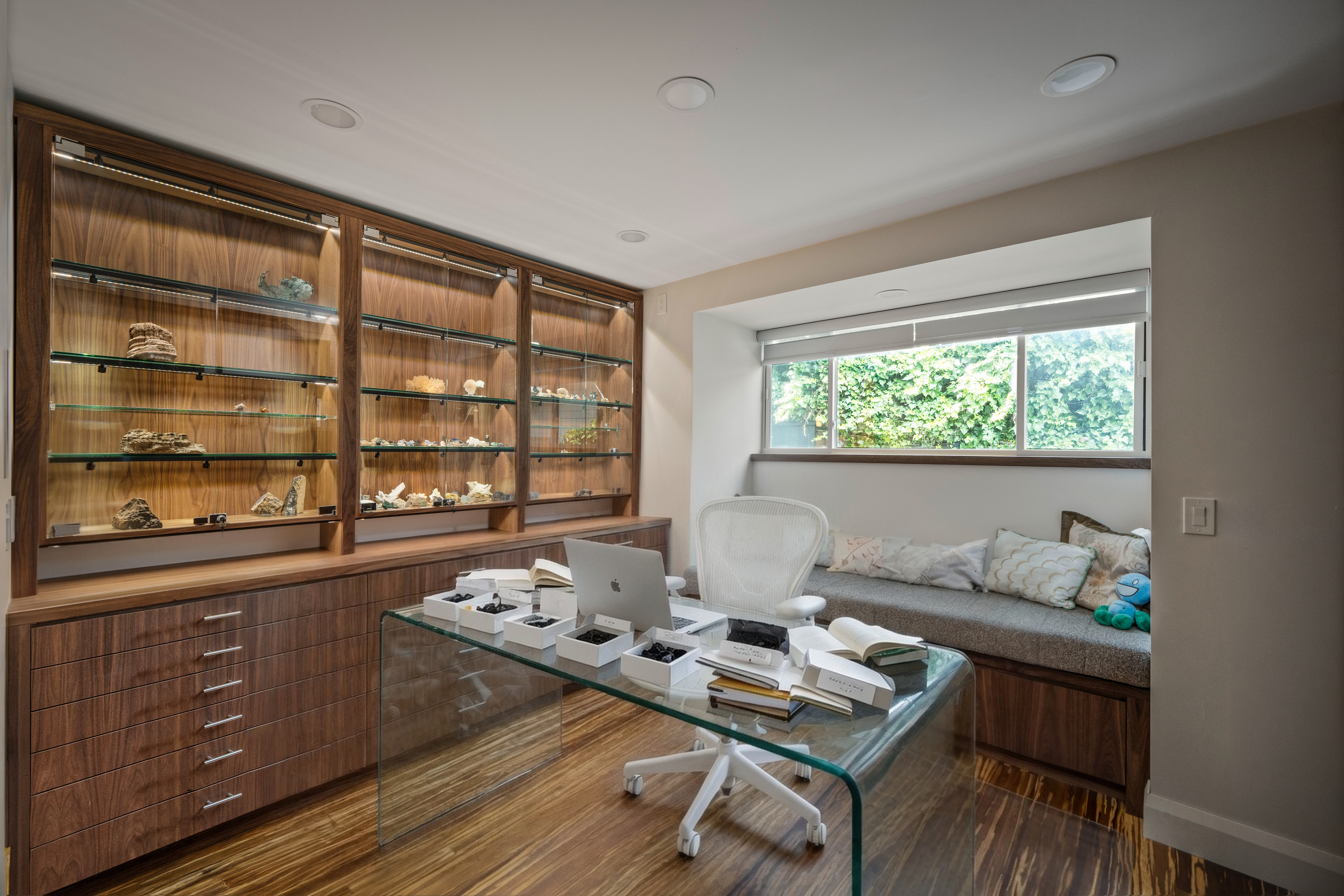 Built-in shelving and a deep window seat transform the room edge into a useful, view-oriented library wall.