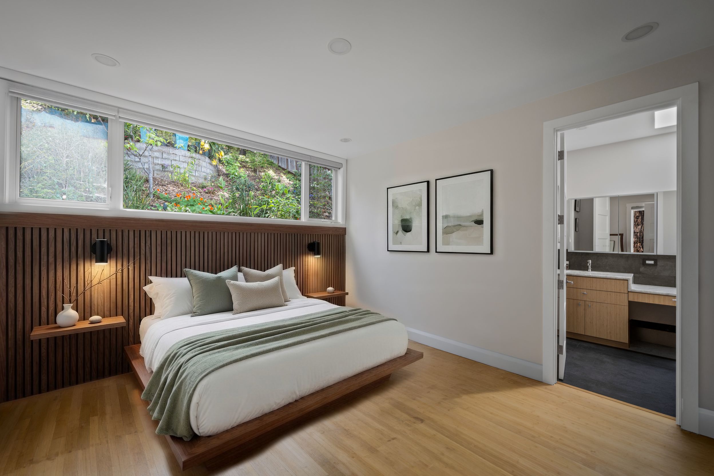 Master bedroom view showing the en suite bath beyond and uphill views through the wall-to-wall clerestory window.