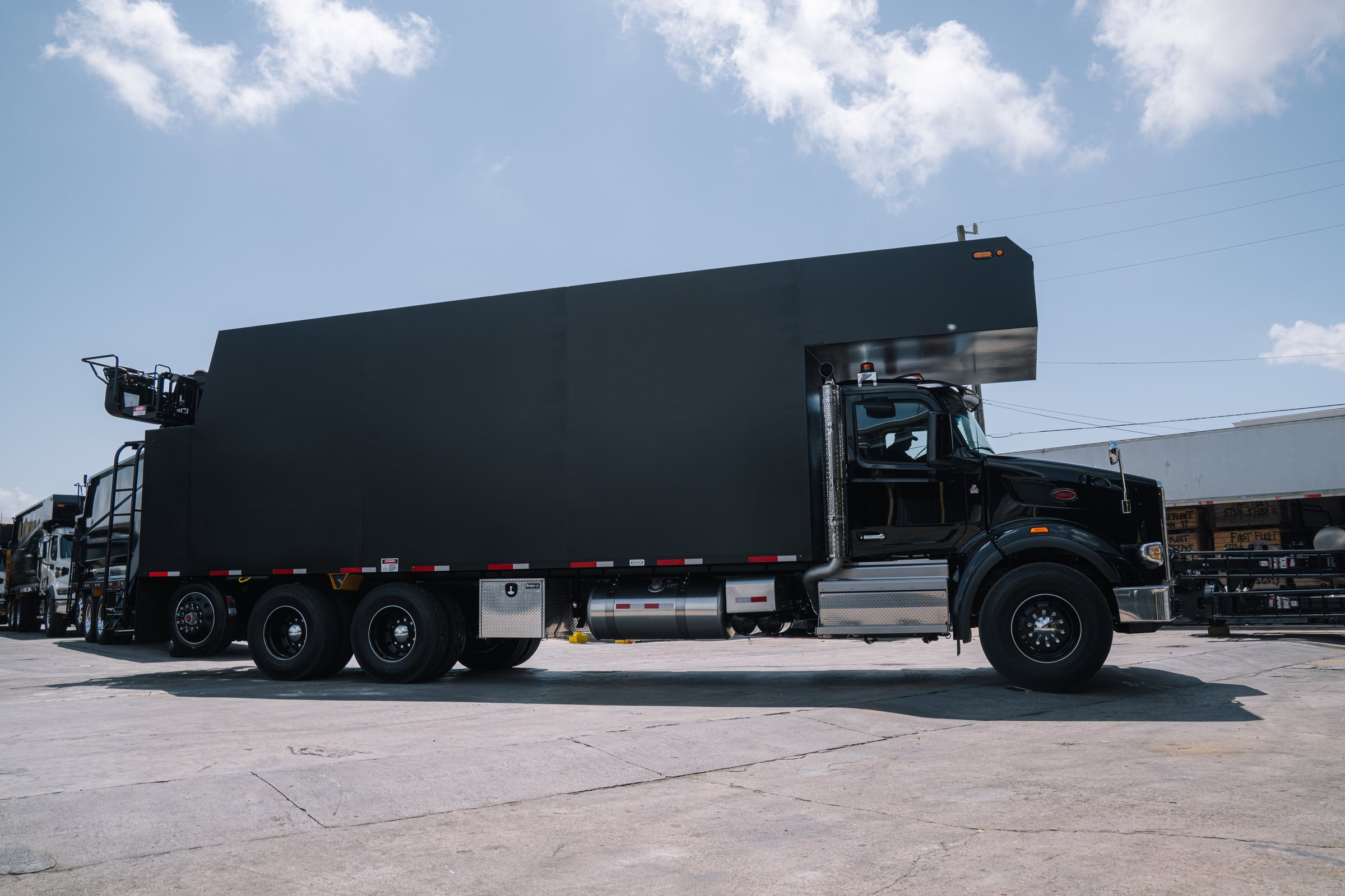 2026 Peterbilt 567 side profile with SERCO 8500SR32 grapple loader at First Fleet Truck Sales