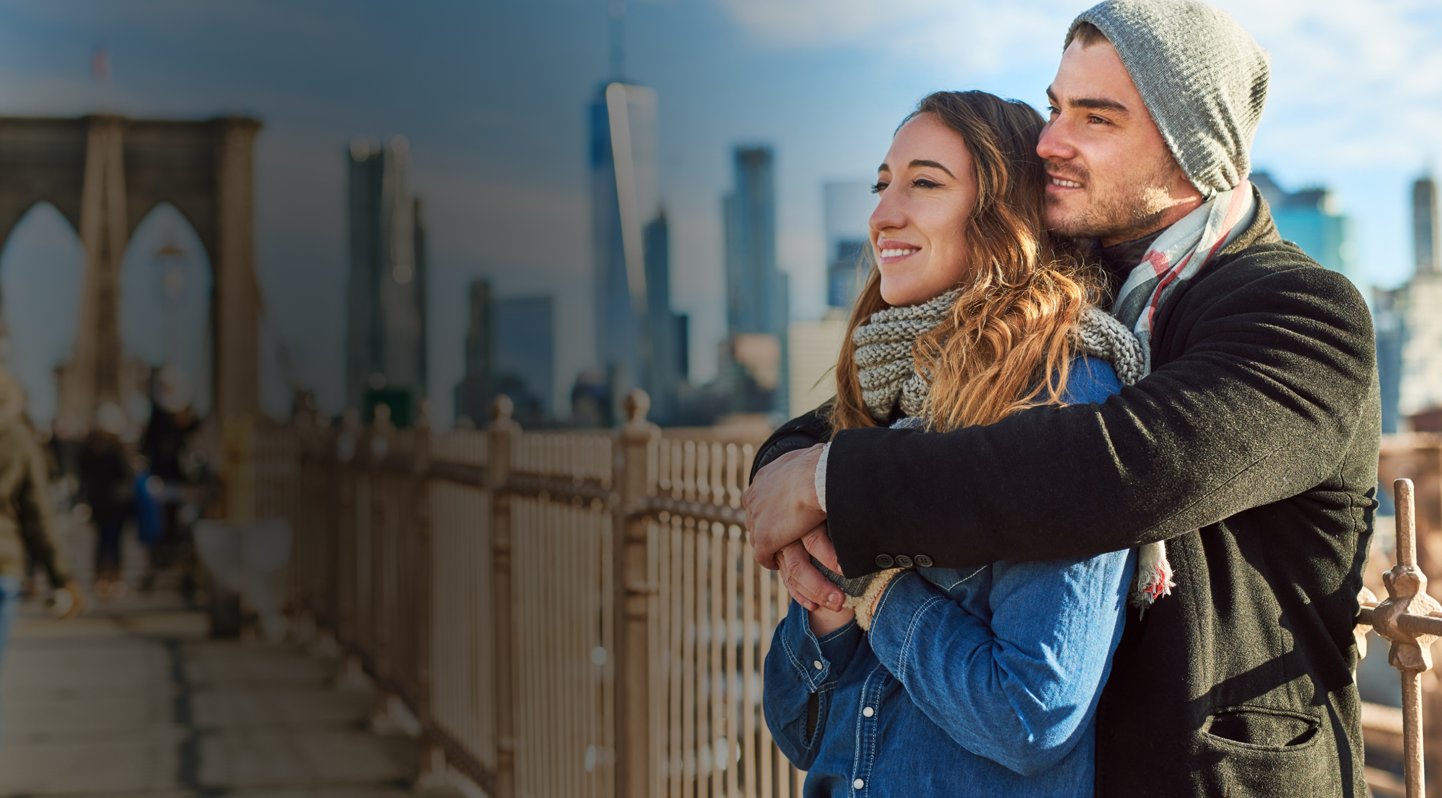 Couple on the Brooklyn Bridge with the Manhattan skyline behind them
