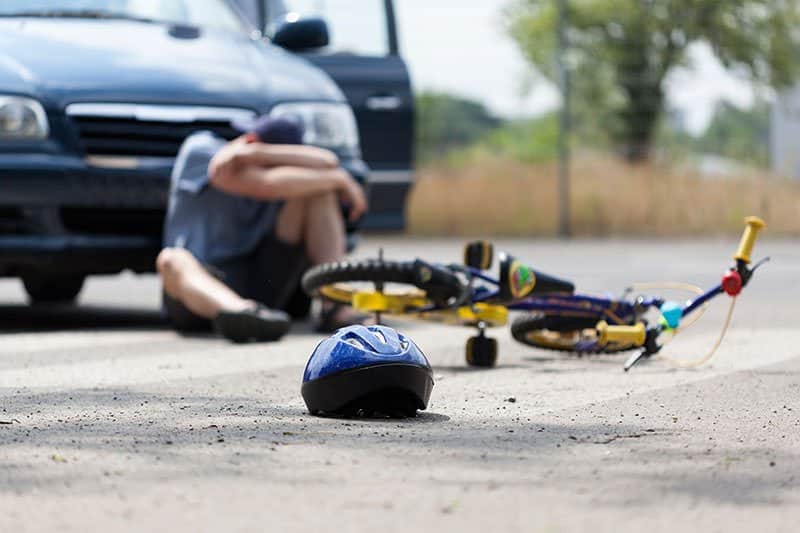 Victim sitting on the ground after being involved in a Bicycle accident