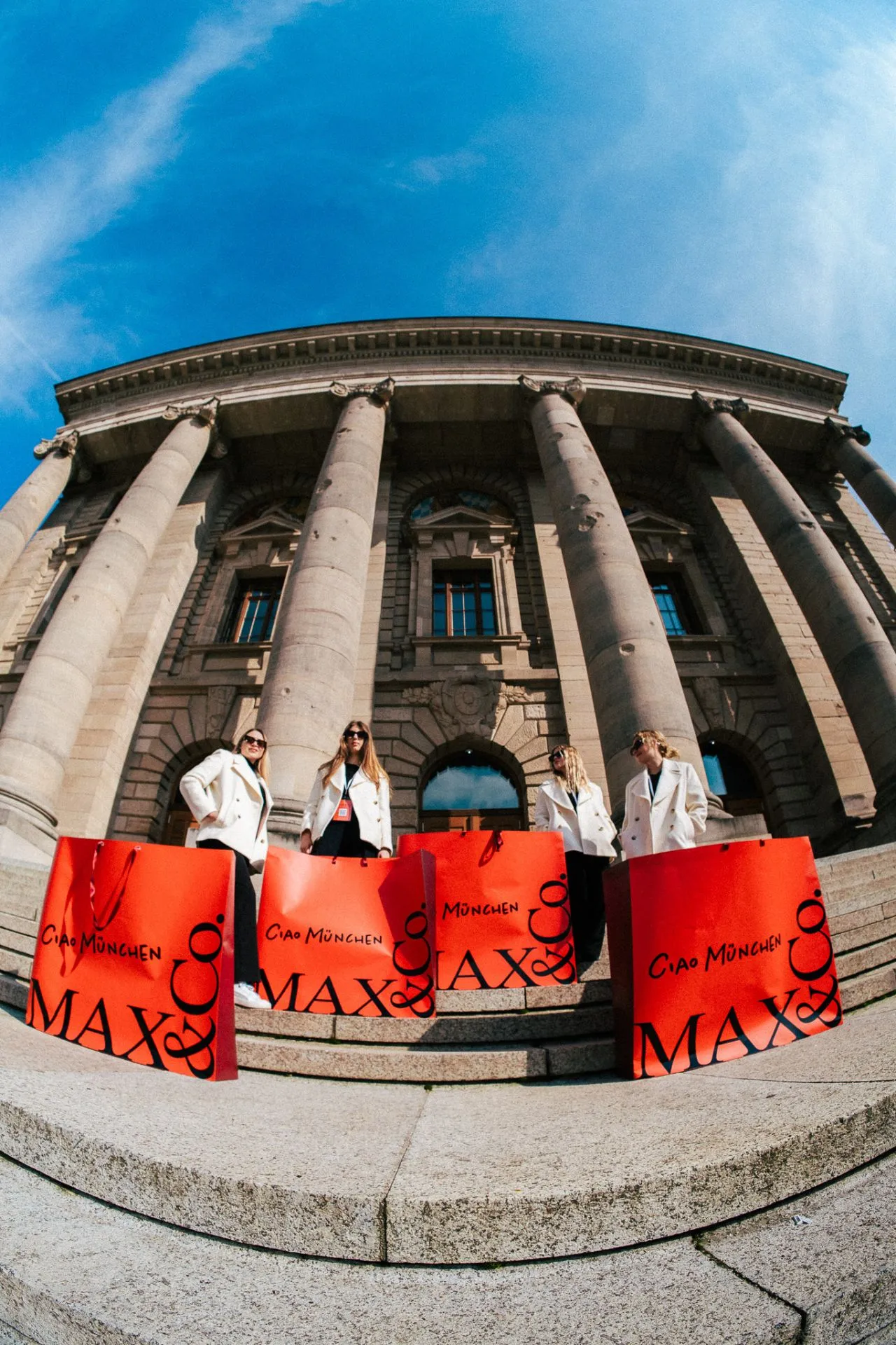 Promotion-Team mit gebrandeten Werbetaschen vor einem historischen Gebäude