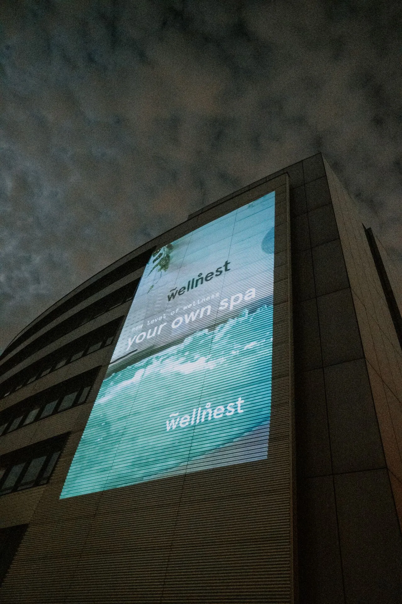Großflächige Wellnest-Projektion an einer Gebäudefassade