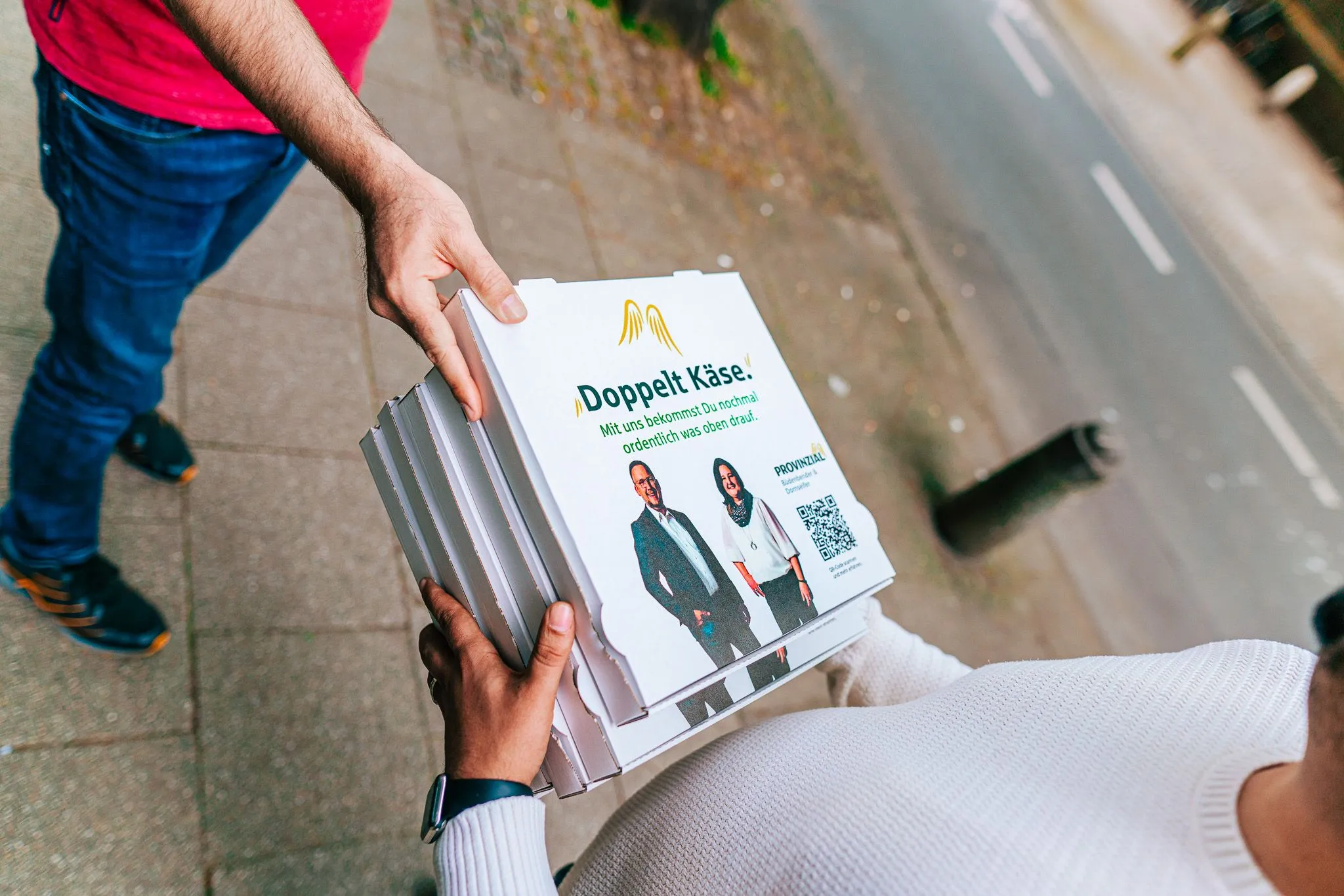 Übergabe eines Werbeflyers bei einer Flyerverteilung auf der Straße
