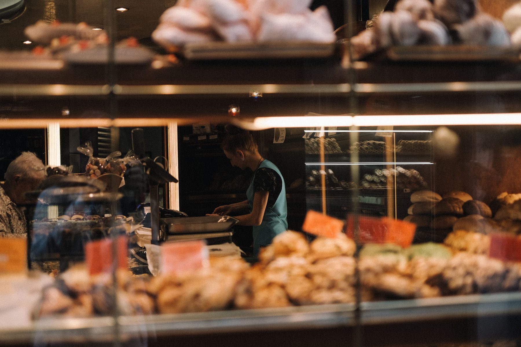Verkäuferin hinter der Theke einer Bäckerei bedient am Morgen Kundschaft