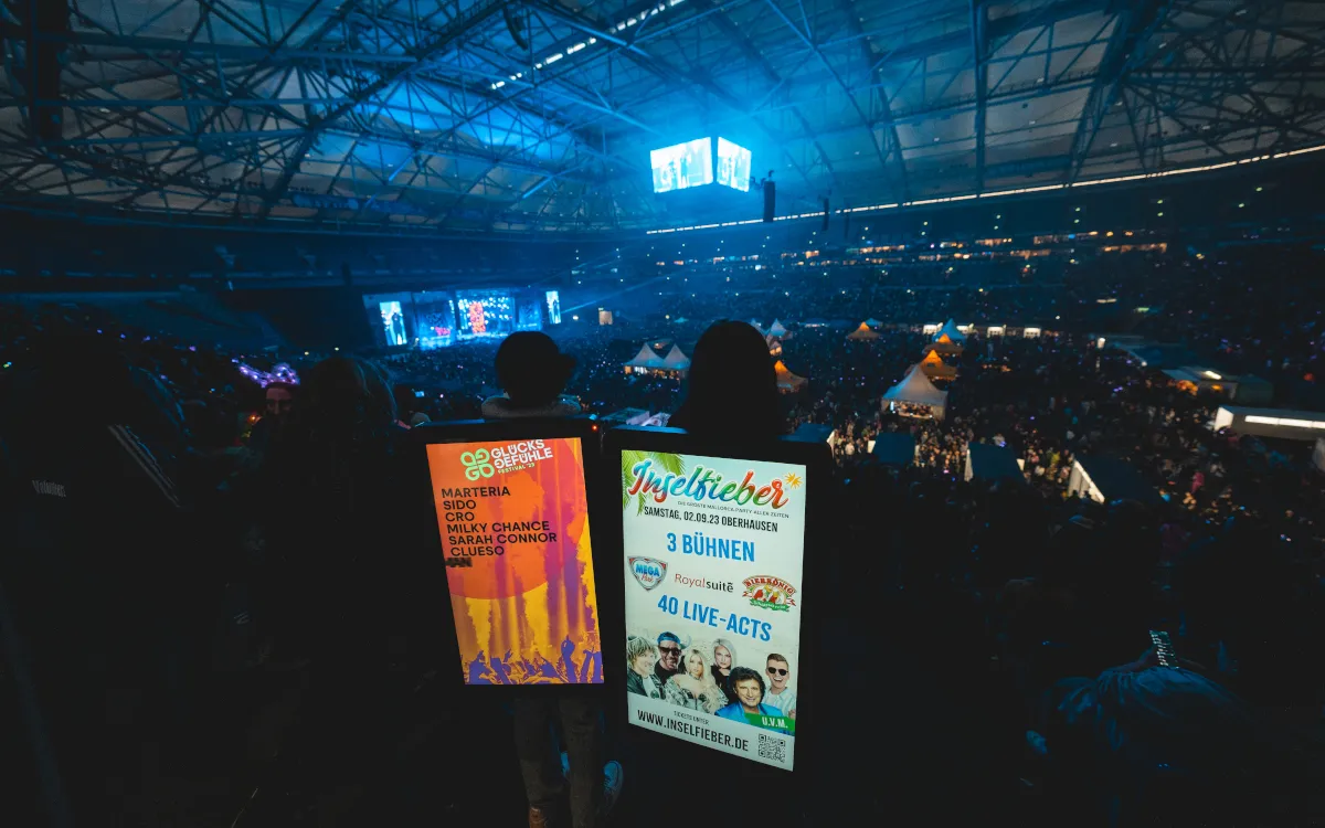 Zwei Promoter mit Walking Screens vor der Bühne bei einem Musikfestival