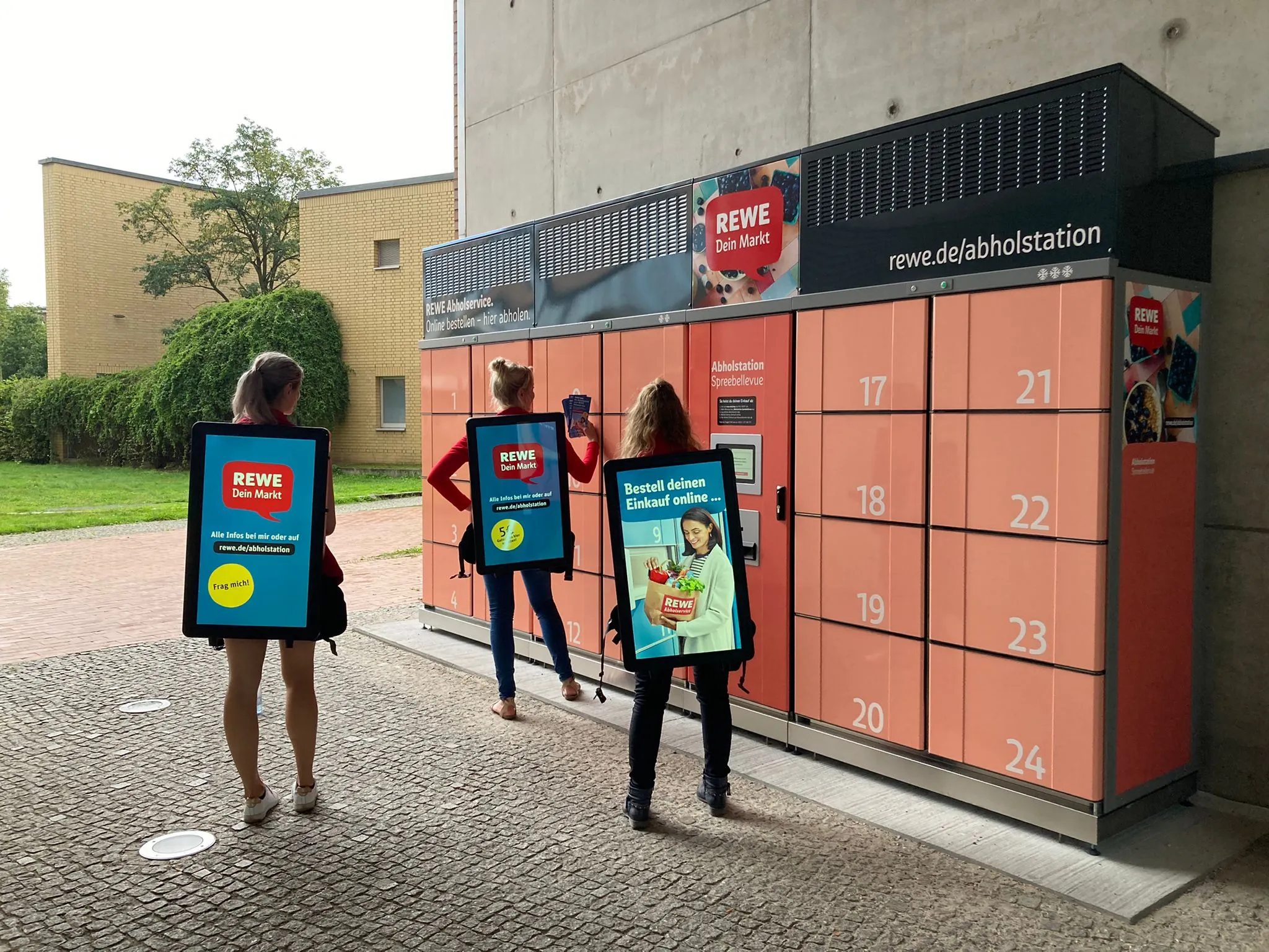 Drei Promoter mit Walking Screens vor einer Abholstation im Einsatz