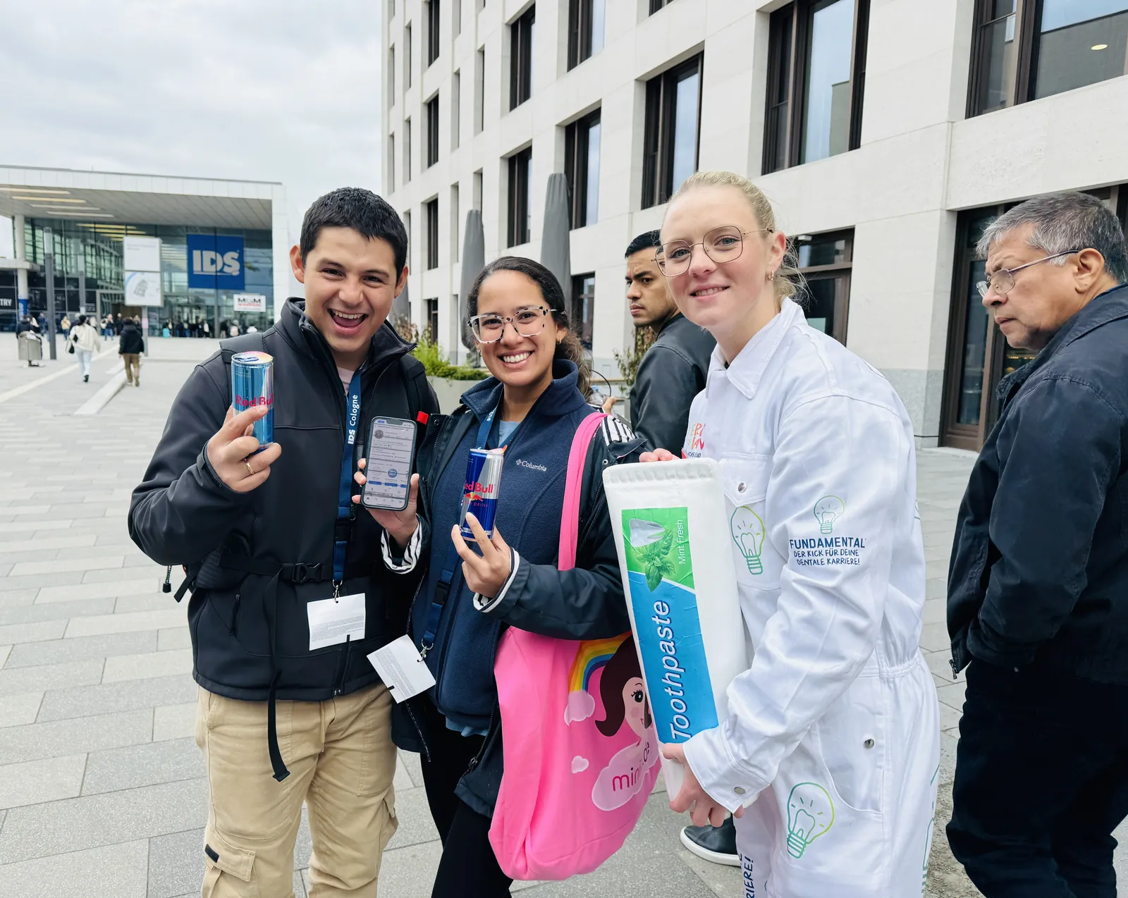 Promotion-Team mit Messebesuchern und Produktproben vor einer Messehalle