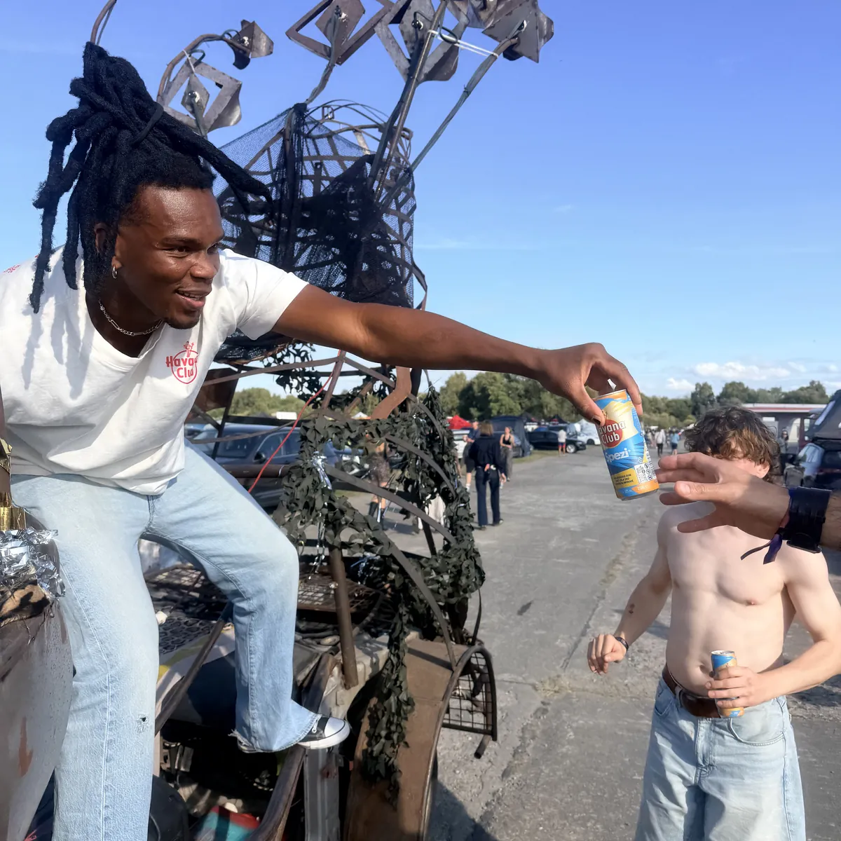 Promoter von Havana Club reicht bei einem Festival eine Getränkedose an einen Besucher