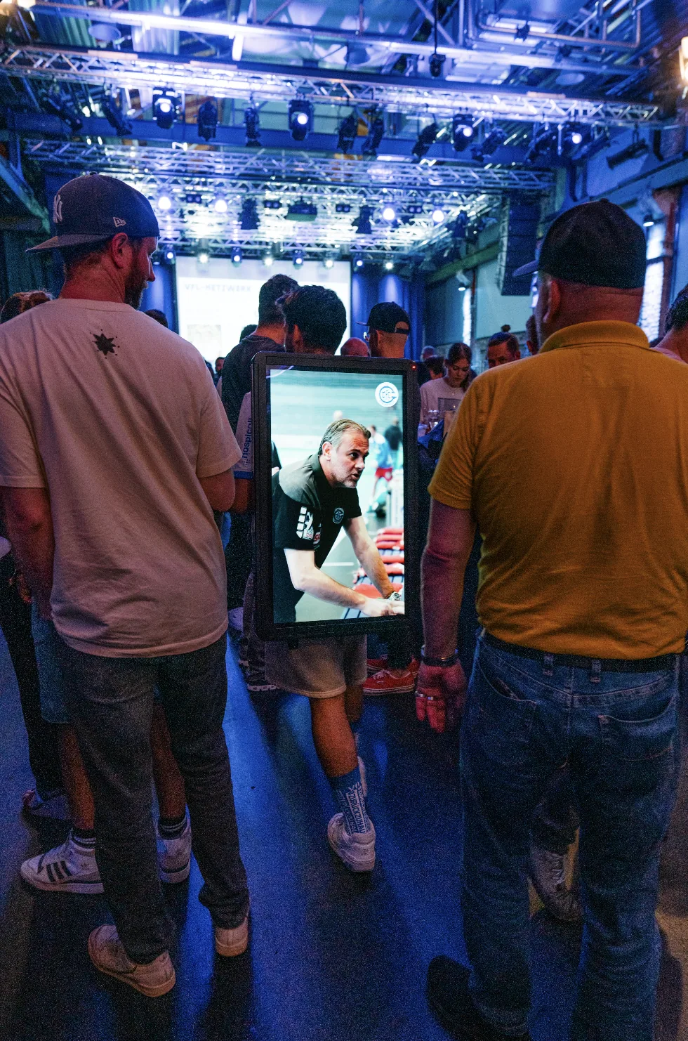 Promoter trägt einen Walking Screen mit Dauerkarten-Werbung durch die Zuschauer in der VfL-Arena