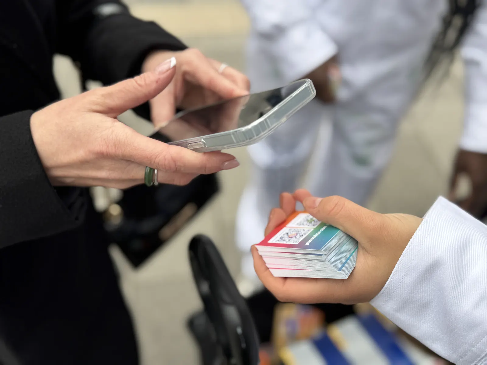 Promoterin scannt beim Sampling einen Code auf dem Smartphone einer Passantin
