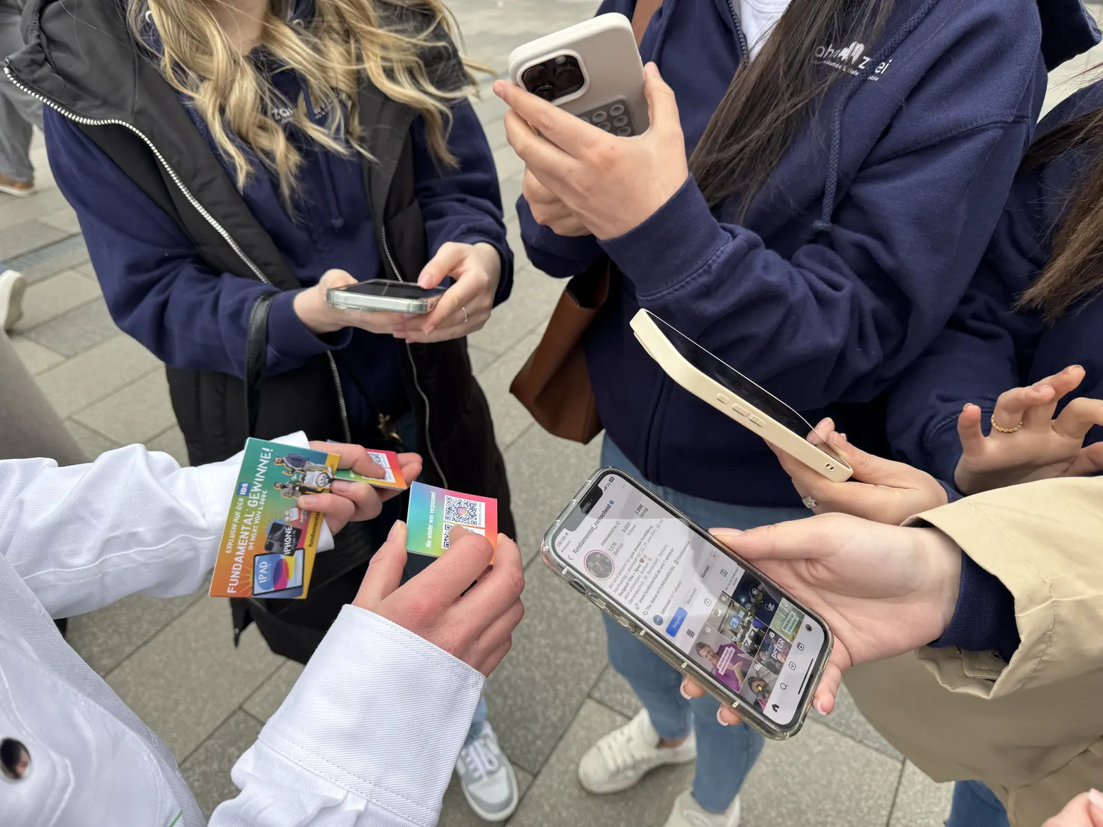 Passantinnen scannen beim Street Sampling einen QR-Code auf dem Smartphone