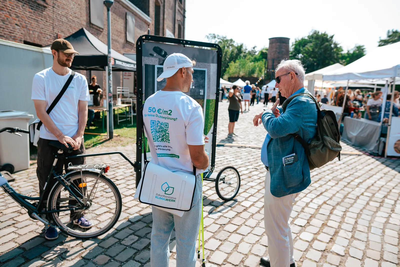 Promoter mit Bike Poster im Gespräch mit einem Passanten