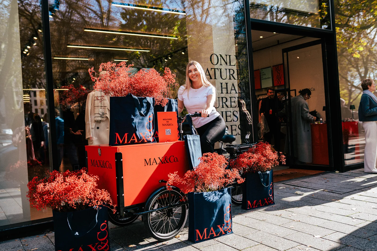 Gebrandetes Promotion-Fahrrad mit MAX&Co Taschen vor dem Store