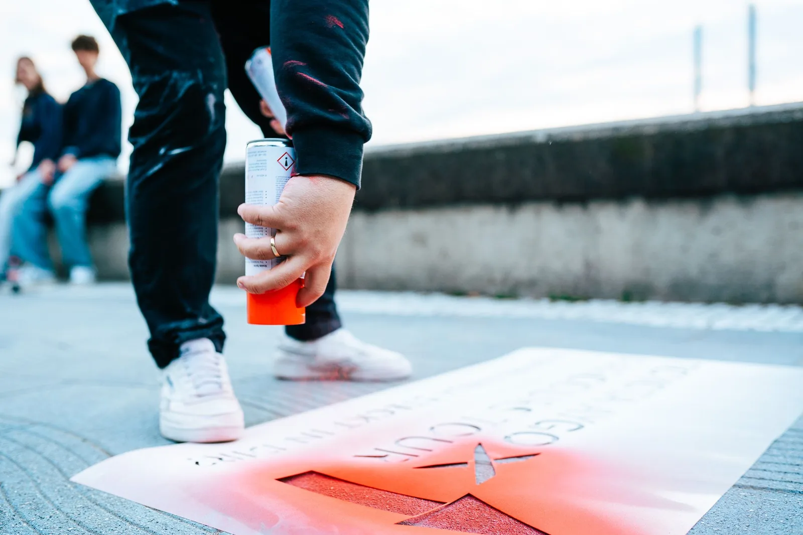 Passanten laufen über eine frisch aufgebrachte Street-Stencil-Bodenwerbung