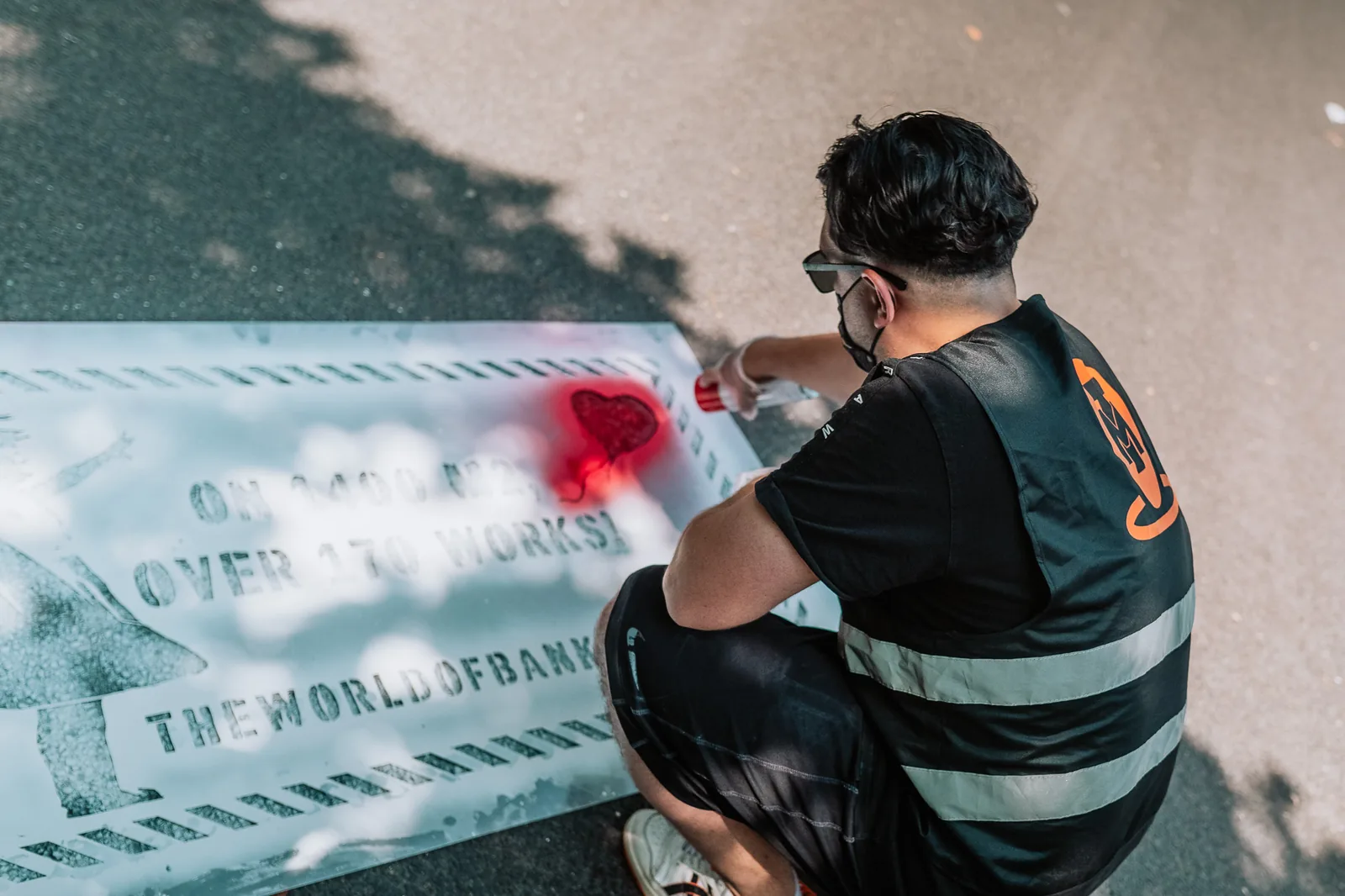 Mitarbeiter bringt eine Street-Stencil-Botschaft auf dem Gehweg an