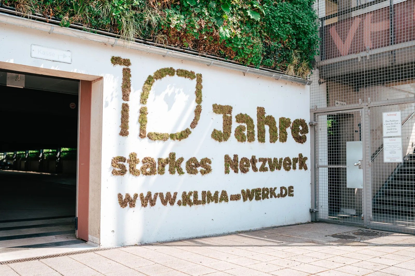 Green Graffiti mit Moosschrift 10 Jahre starkes Netzwerk an einer Hauswand