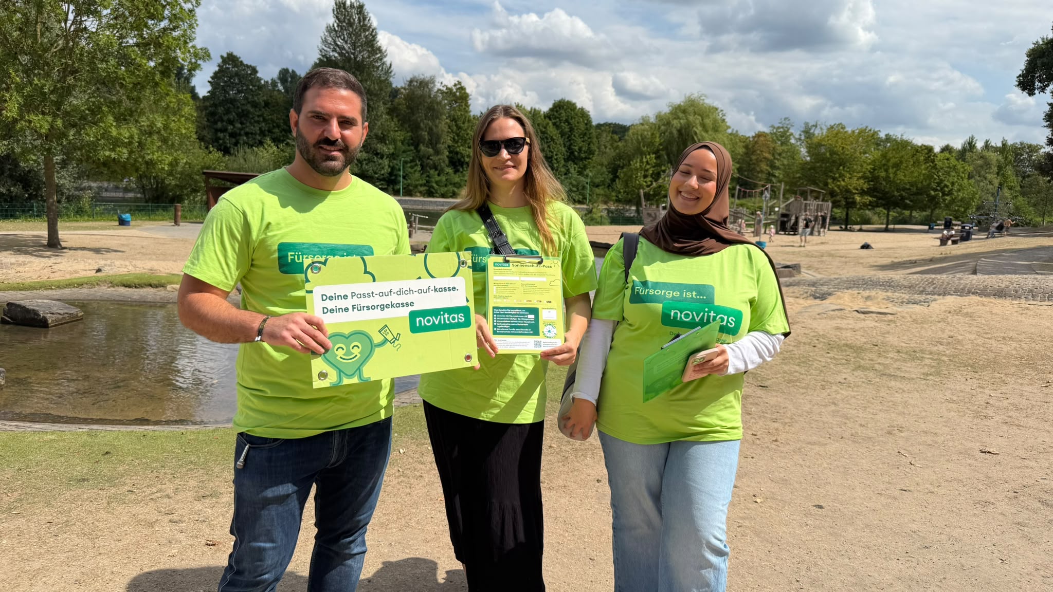 Promotion-Team mit Sonnenschutz-Pass und Sommerquiz-Schild am Baldeneysee