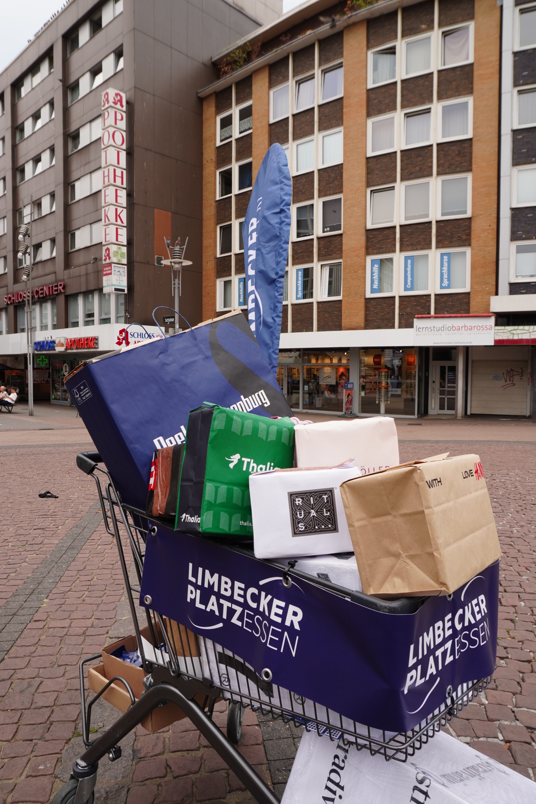 Der gebrandete Einkaufswagen des Limbecker Platz voller Store-Pakete in der Fussgaengerzone