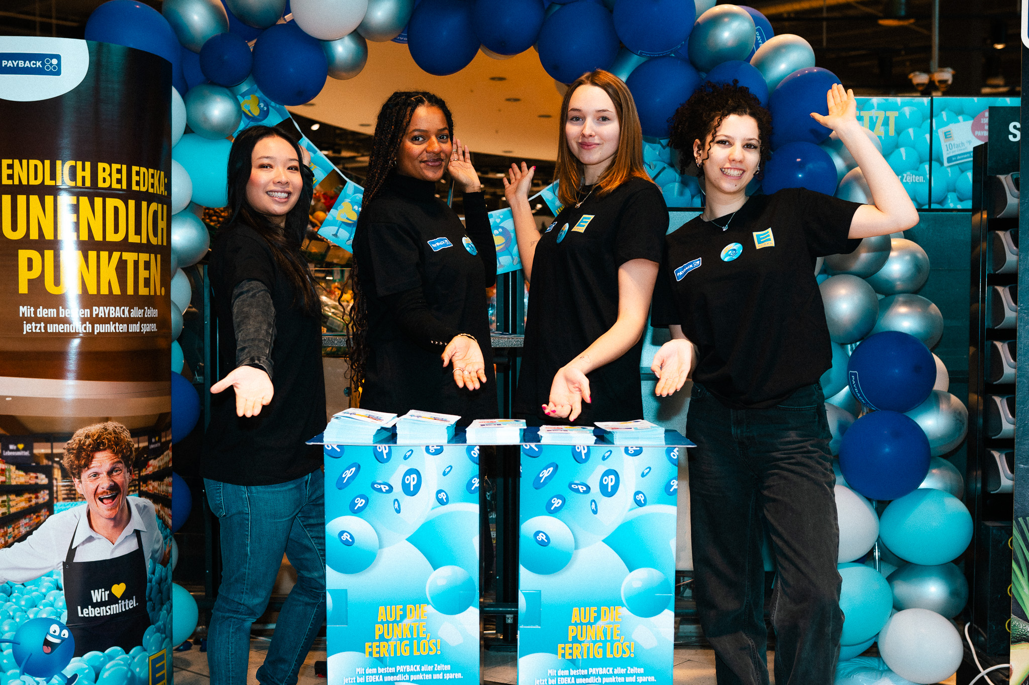 4 Personen am Payback Stand im Rewe