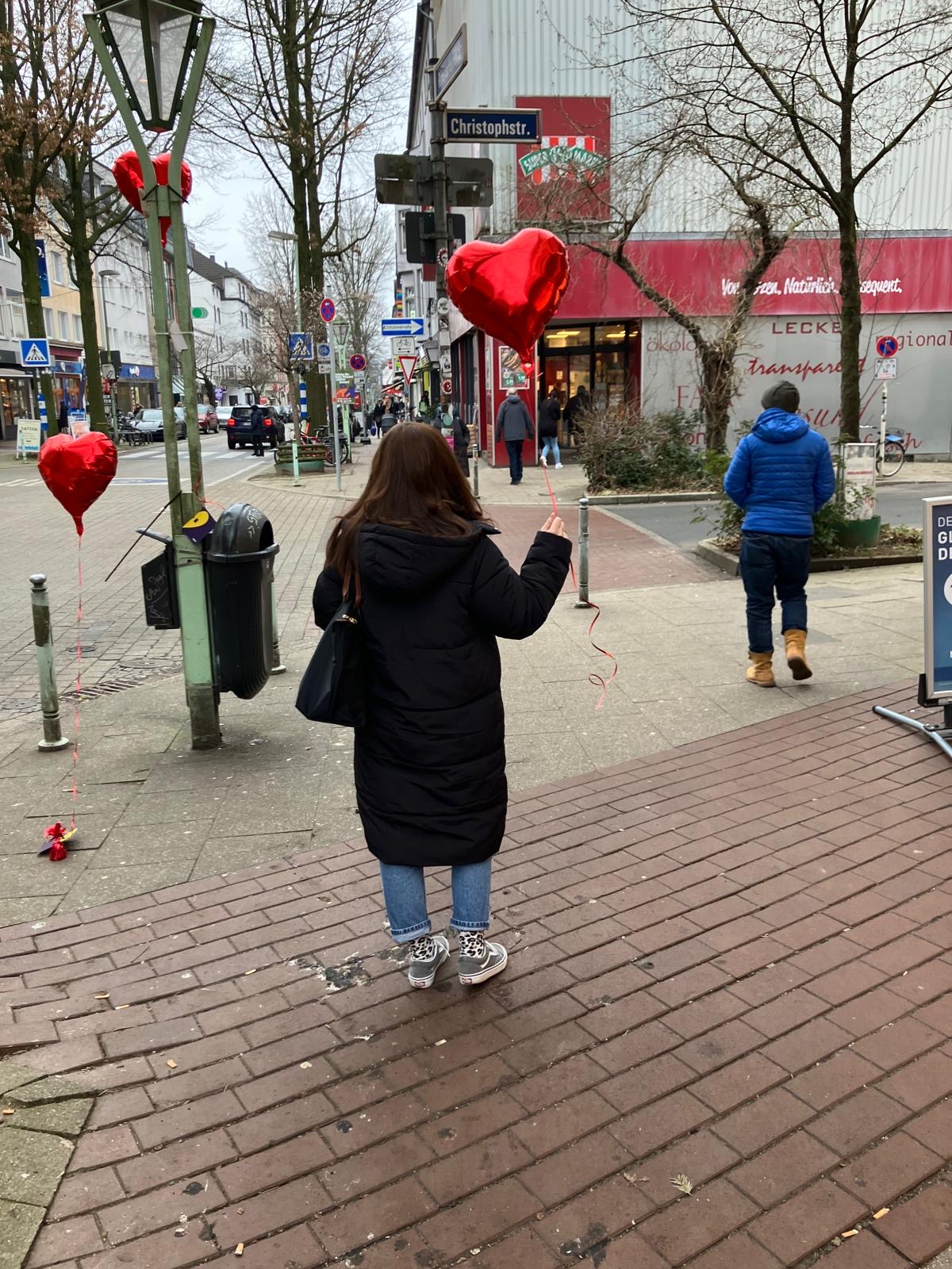 Person mit Herzluftballon in der Hand