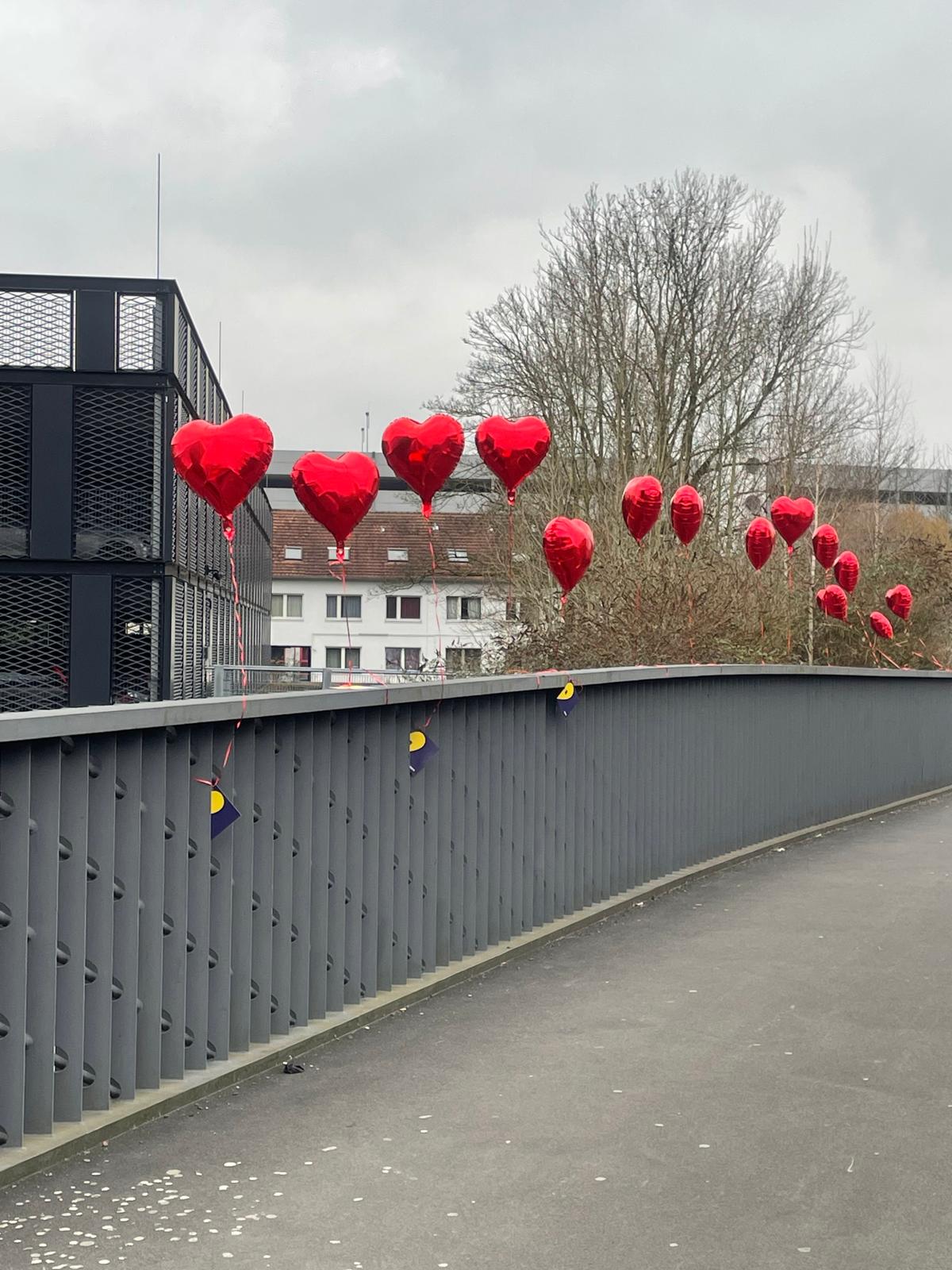 Herzluftballons an einer Brücke in der Stadt