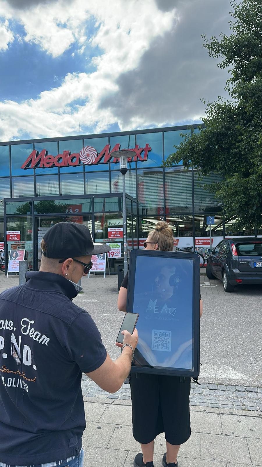 Promoter mit Walking Screen vor dem Media Markt
