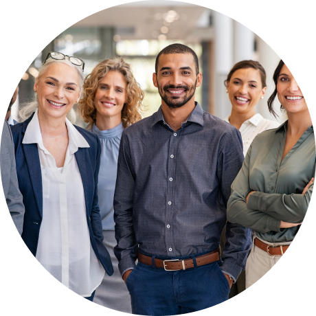 Five diverse professionals smiling and standing together in an office environment.