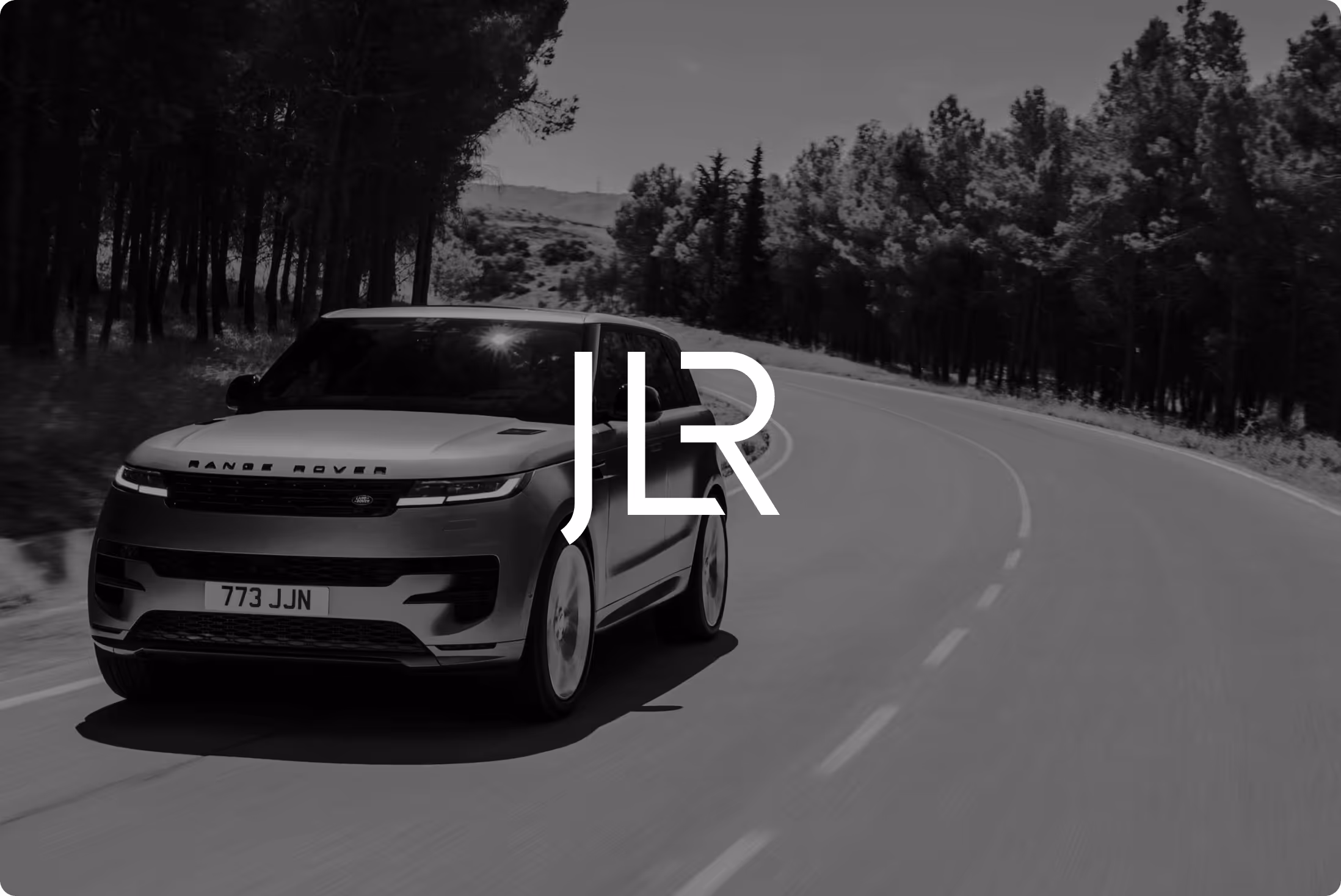 The Jaguar Land Rover (JLR) logo atop brand imagery of a Range Rover on the open road