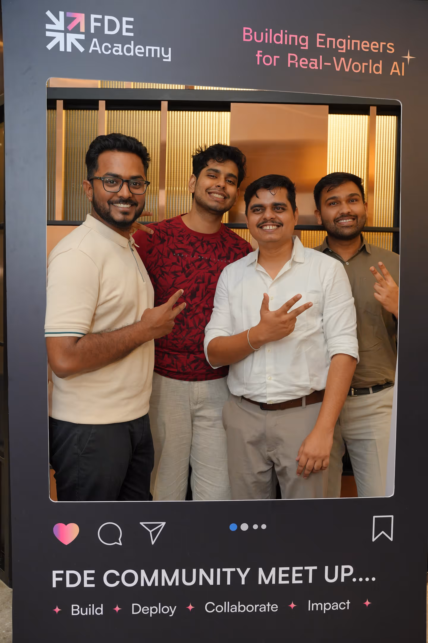 Four men smiling and posing with peace signs at FDE Academy community meet up photo frame.