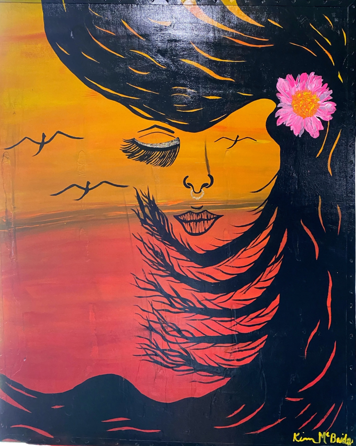 Artistic face of woman with closed eyes, flower in hair, and flowing black hair against sunset sky.